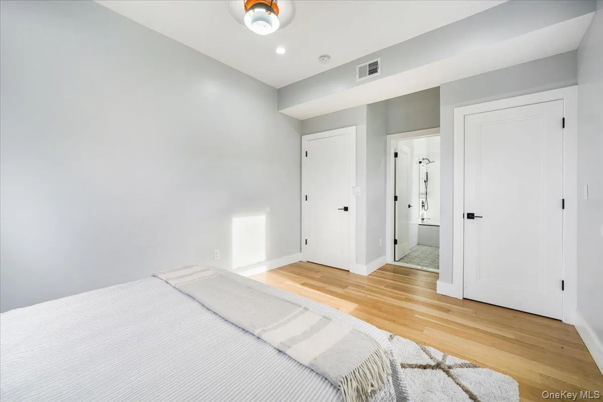 Unfurnished bedroom with light wood finished floors, a closet, and connected bathroom Unfurnished bedroom with light wood finished floors, a closet, and connected bathroom