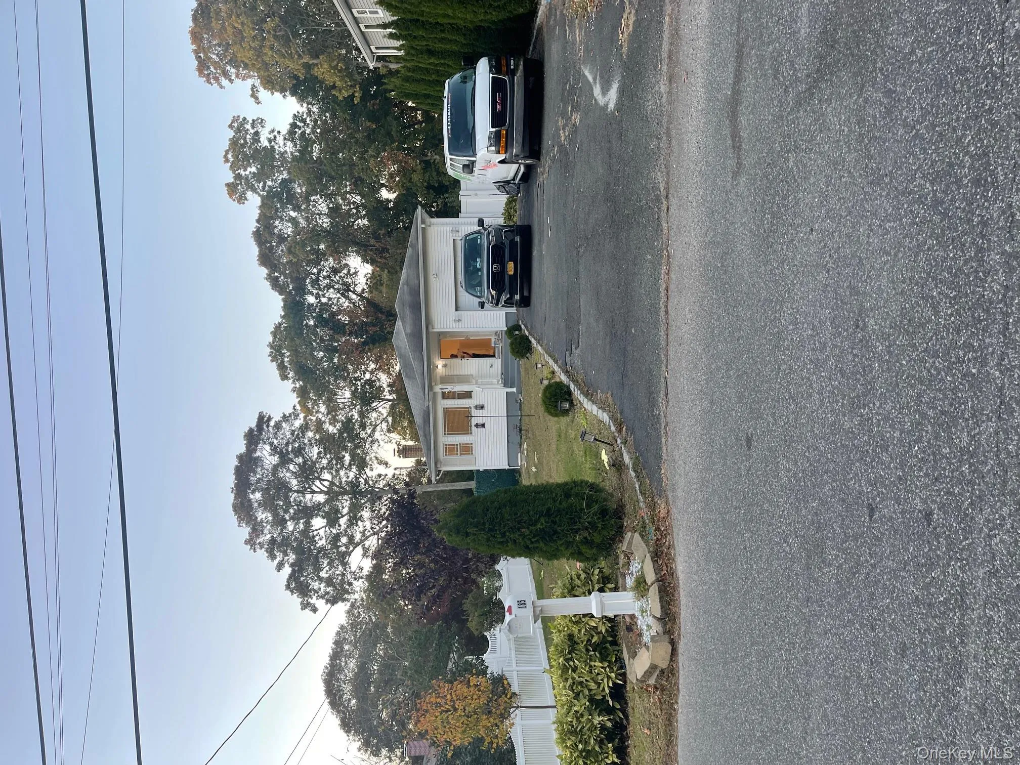 View of front of home featuring driveway, a chimney, and an attached garage View of front of home featuring driveway, a chimney, and an attached garage