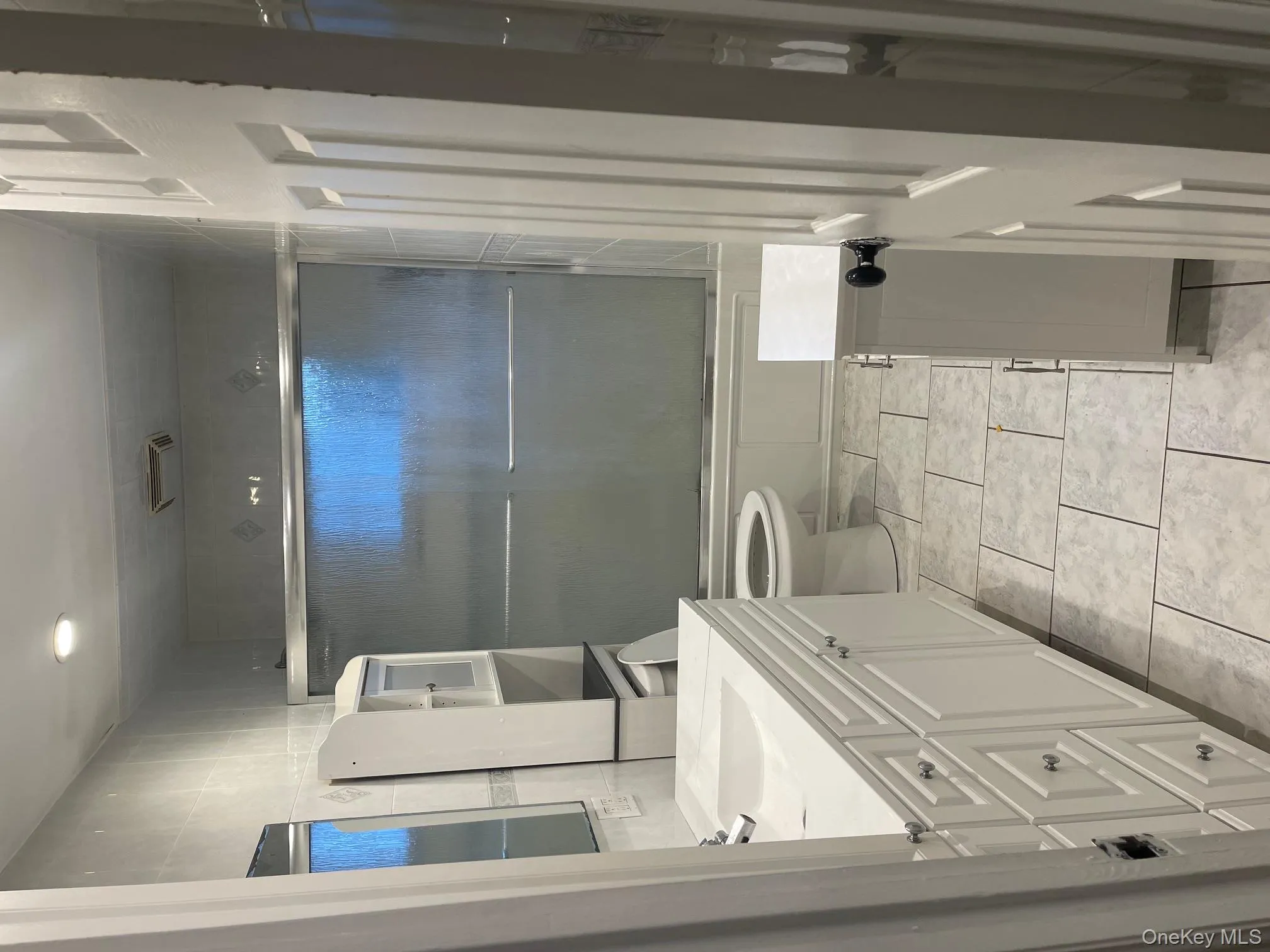 Full bathroom with vanity, combined bath / shower with glass door, and light tile patterned flooring Full bathroom with vanity, combined bath / shower with glass door, and light tile patterned flooring