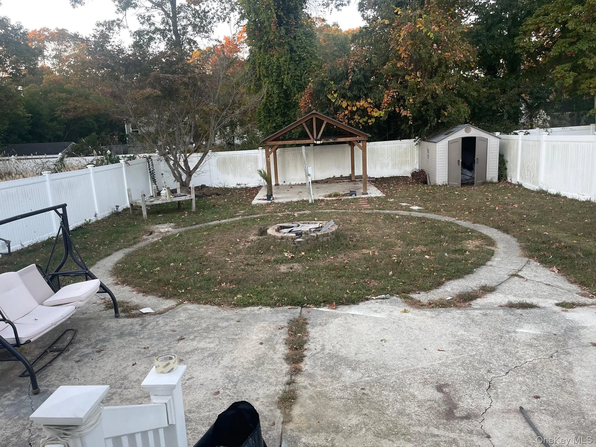 Fenced backyard with a patio and a storage shed Fenced backyard with a patio and a storage shed