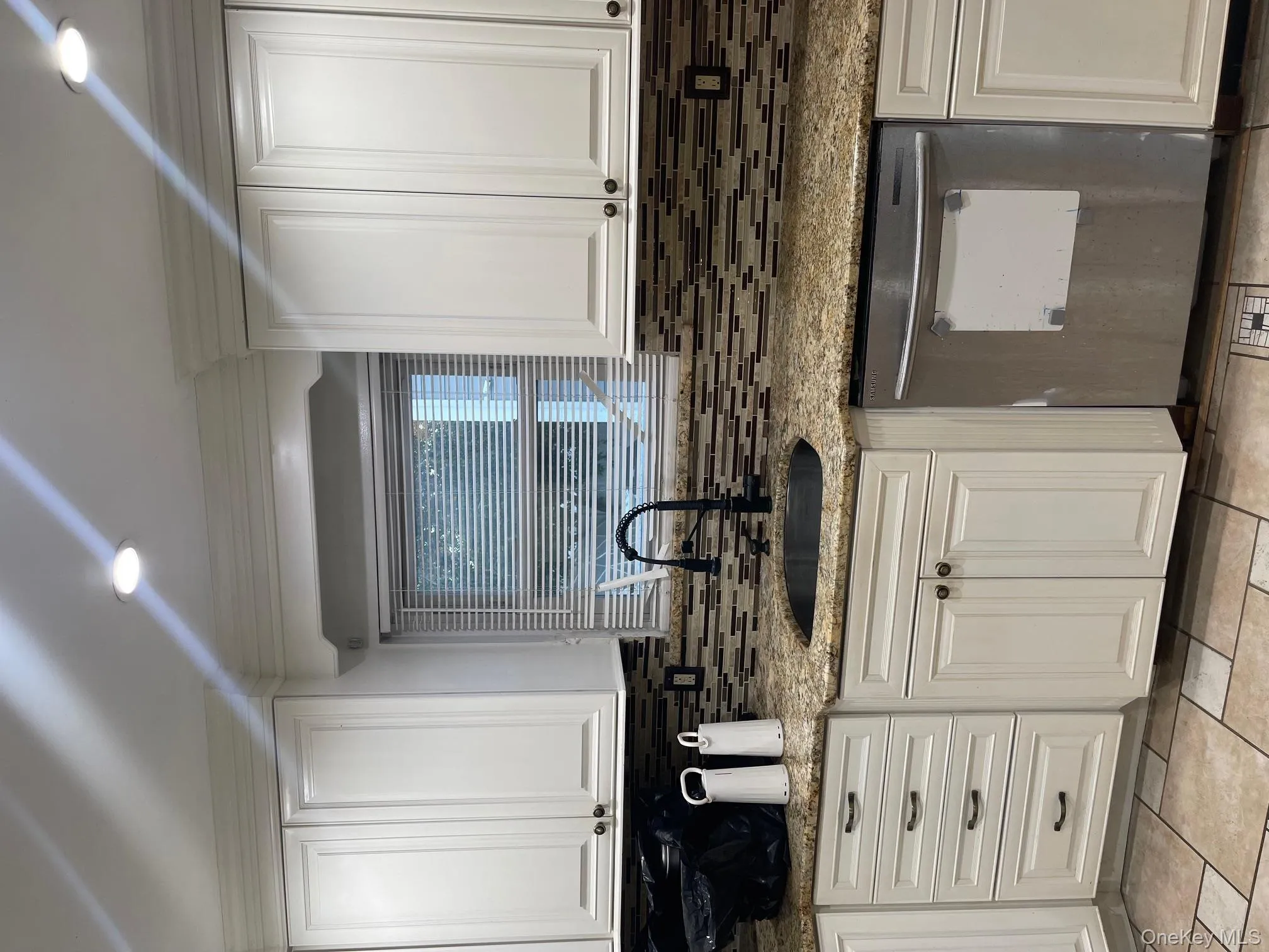 Kitchen with white cabinets, dishwashing machine, light stone counters, decorative backsplash, and recessed lighting Kitchen with white cabinets, dishwashing machine, light stone counters, decorative backsplash, and recessed lighting