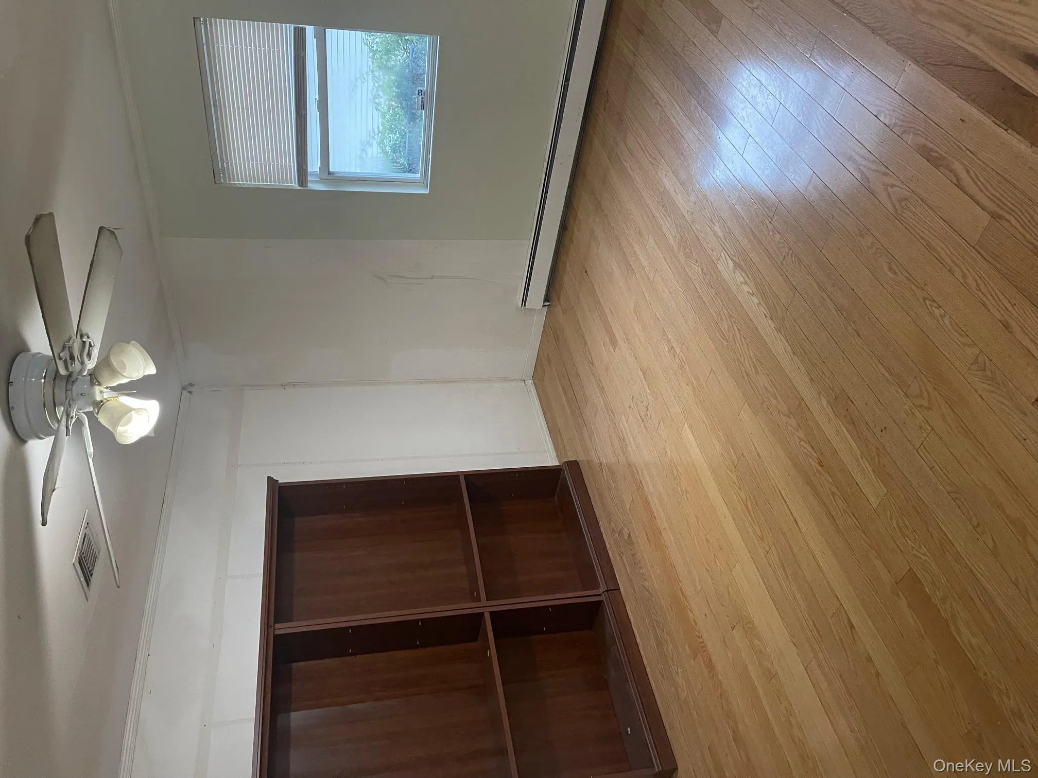 Unfurnished bedroom featuring light wood-style flooring, baseboard heating, ceiling fan, and ornamental molding Unfurnished bedroom featuring light wood-style flooring, baseboard heating, ceiling fan, and ornamental molding