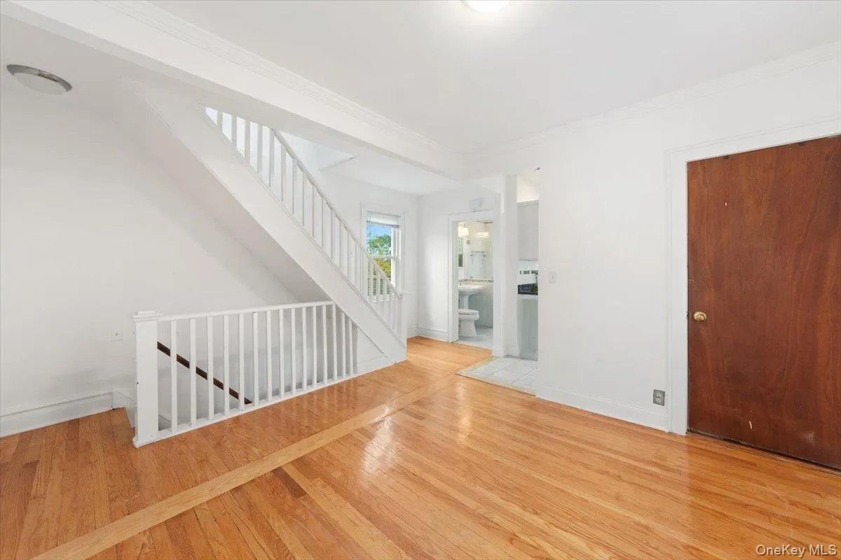 Living room featuring light wood-style floors and stairway to 2nd floor . Living room featuring light wood-style floors and stairway to 2nd floor .