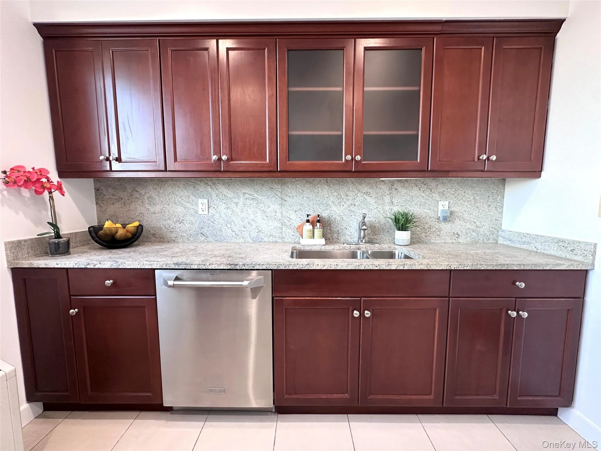Kitchen featuring glass insert cabinets, tasteful backsplash, dishwasher, and granite counters Kitchen featuring glass insert cabinets, tasteful backsplash, dishwasher, and granite counters