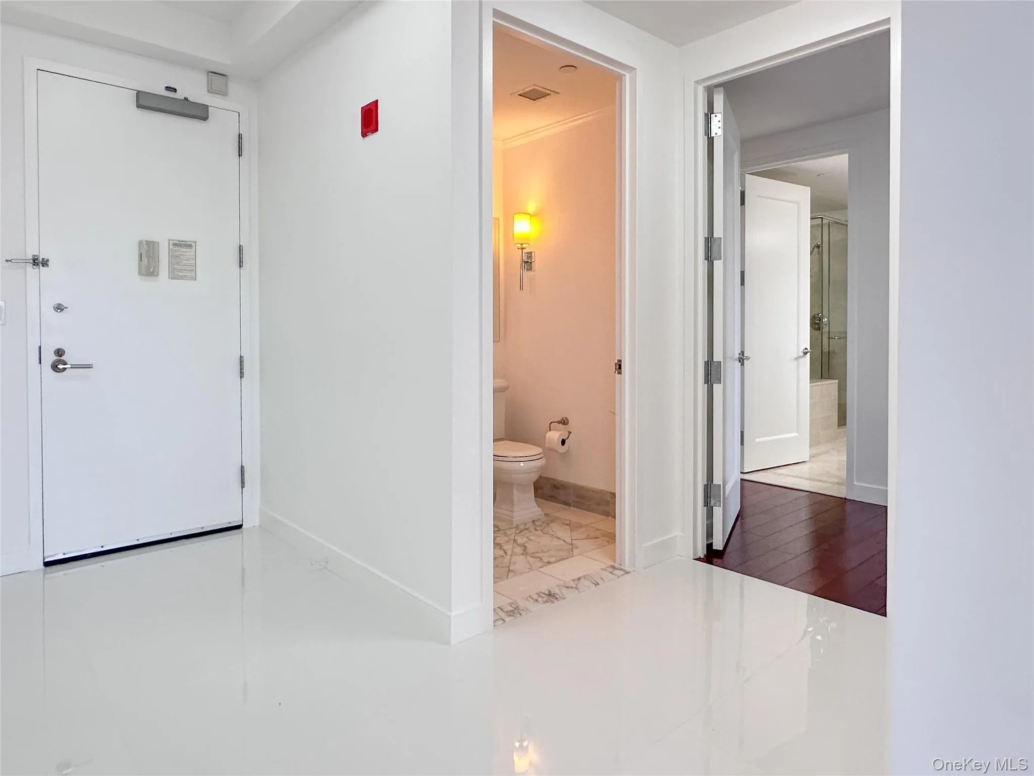 Entrance area with view towards front door, powder room and primary en-suite Entrance area with view towards front door, powder room and primary en-suite