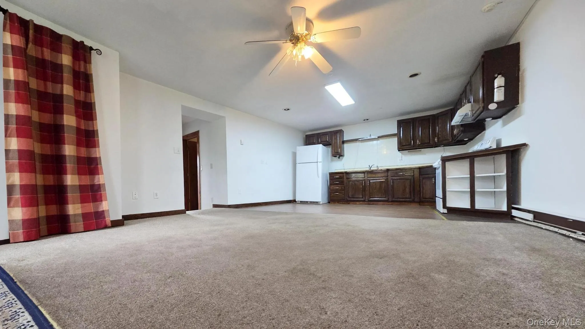 Unfurnished living room featuring a ceiling fan and light carpet Unfurnished living room featuring a ceiling fan and light carpet