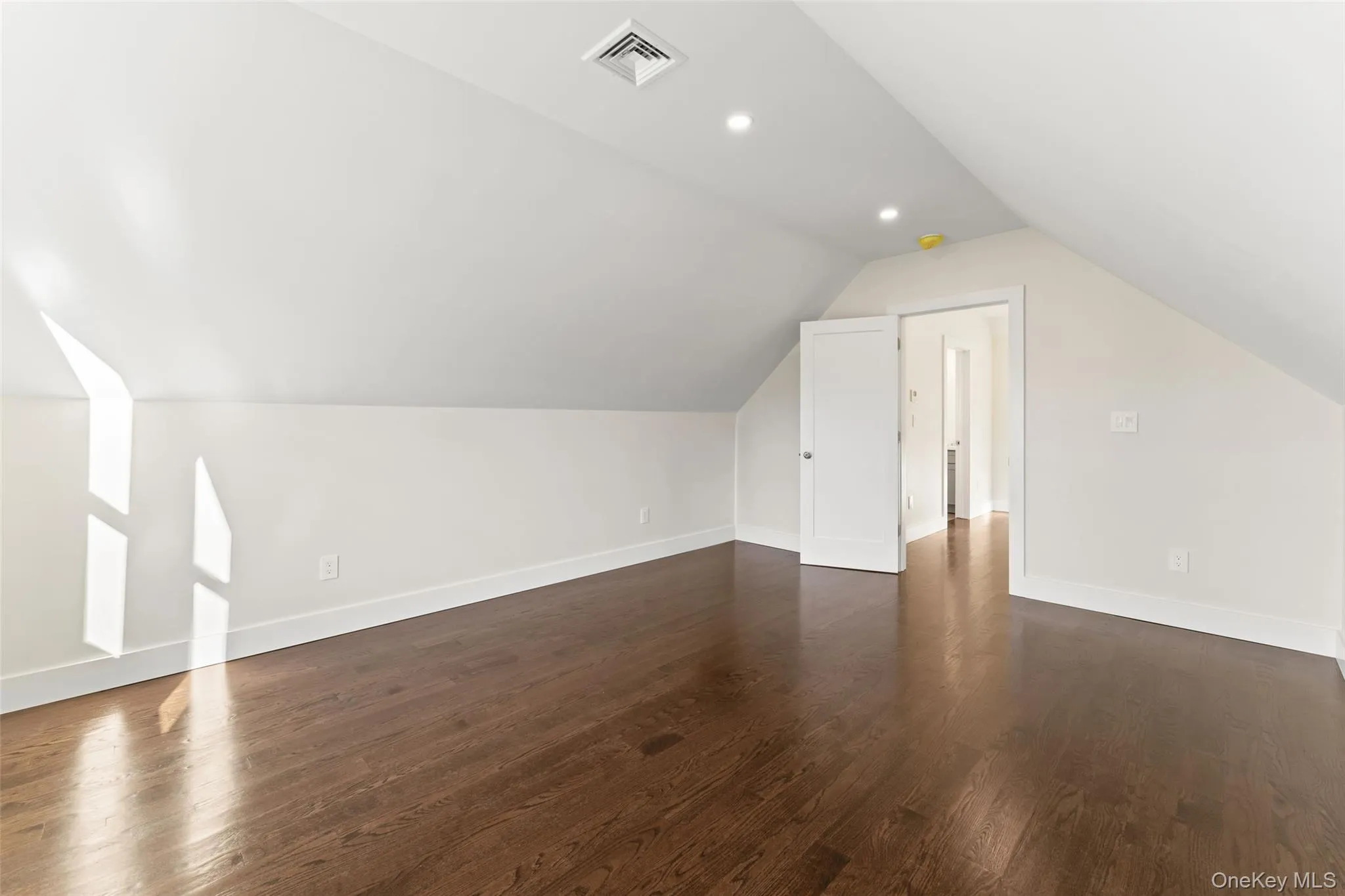 Primary bedroom featuring vaulted ceiling, dark wood-style floors, and recessed lighting Primary bedroom featuring vaulted ceiling, dark wood-style floors, and recessed lighting