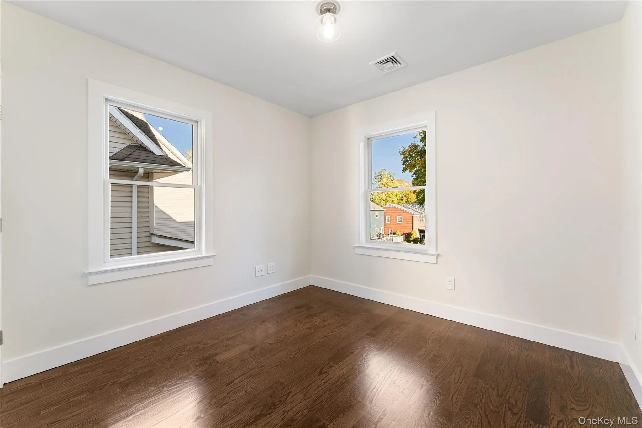 Bedroom featuring dark wood finished floors and healthy amount of natural light Bedroom featuring dark wood finished floors and healthy amount of natural light
