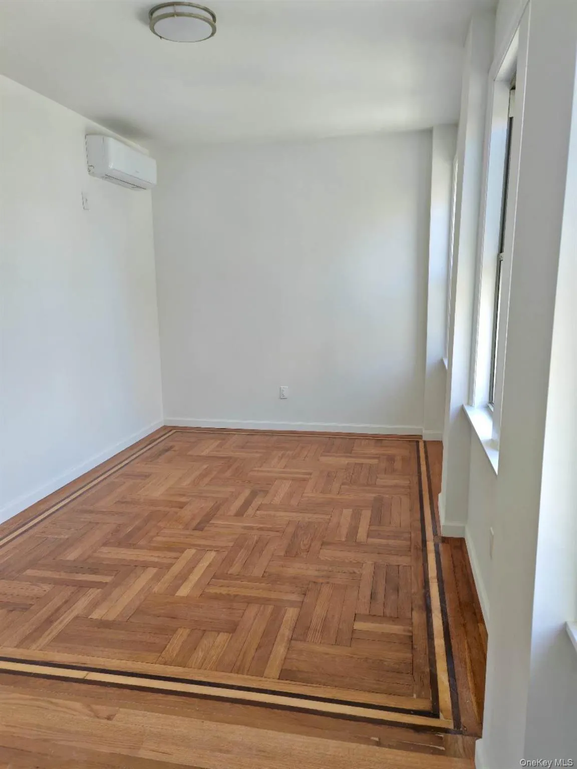 Empty room with baseboards and a wall mounted air conditioner Empty room with baseboards and a wall mounted air conditioner
