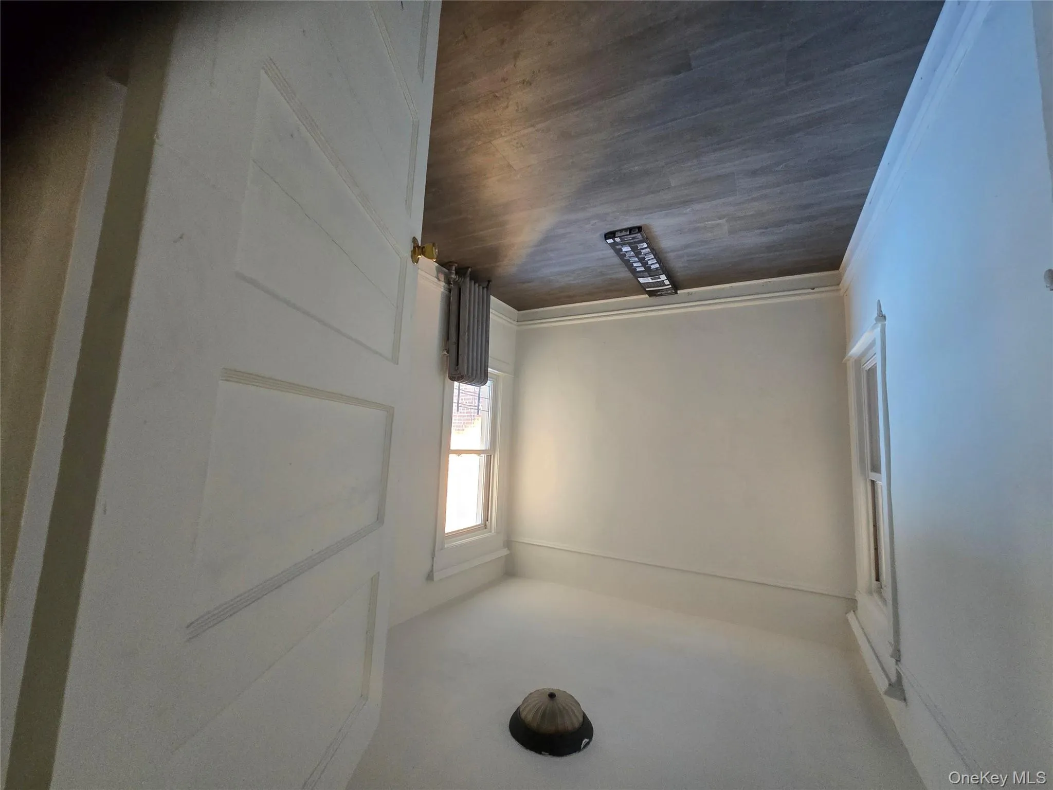 Empty room featuring dark wood finished floors and radiator heating unit Empty room featuring dark wood finished floors and radiator heating unit