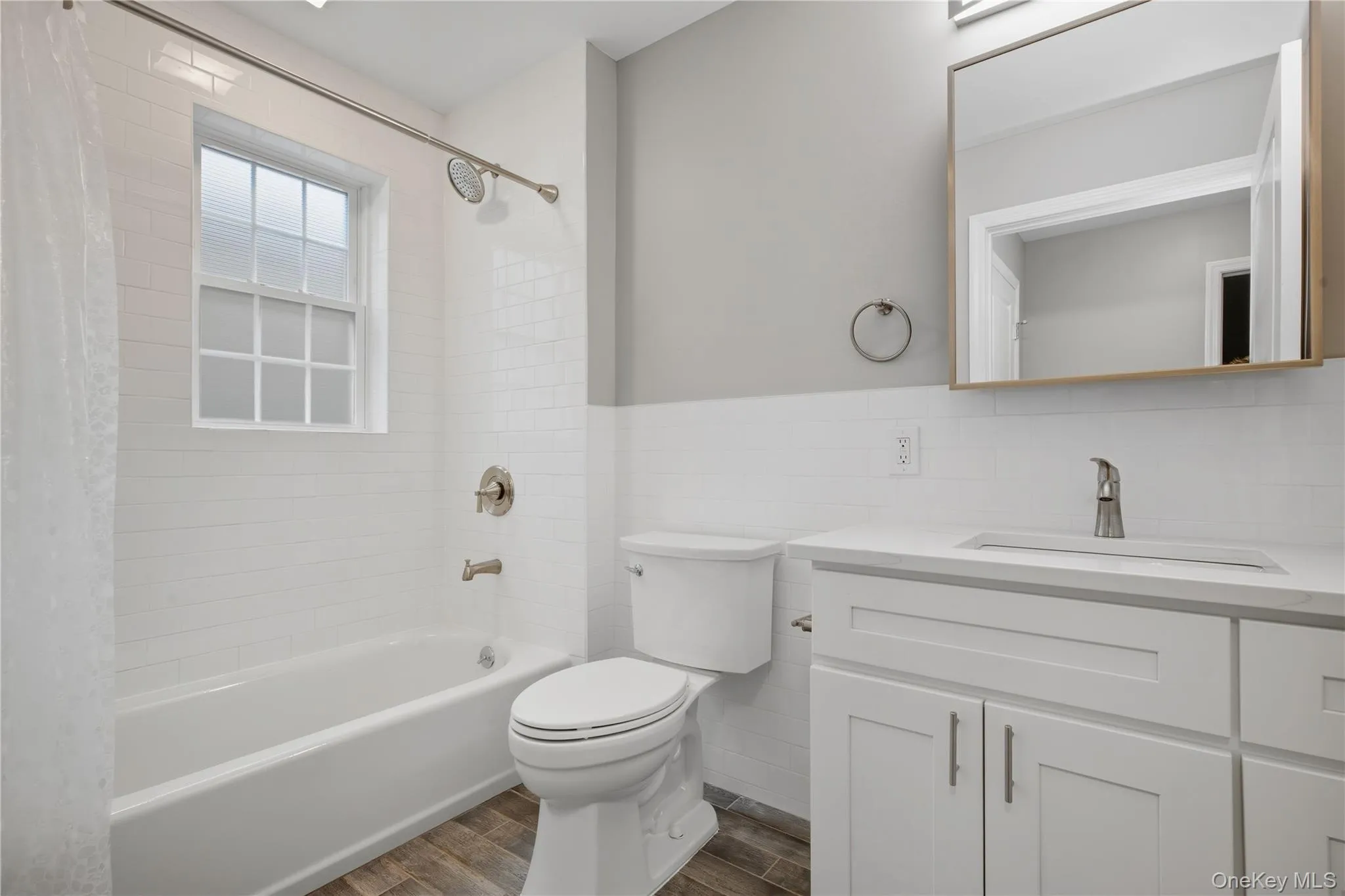 Full bath with white Vanity, Luxury Vinyl Floors, Shower / Tub Combo with Curtain & Subway Tiles Full bath with white Vanity, Luxury Vinyl Floors, Shower / Tub Combo with Curtain & Subway Tiles