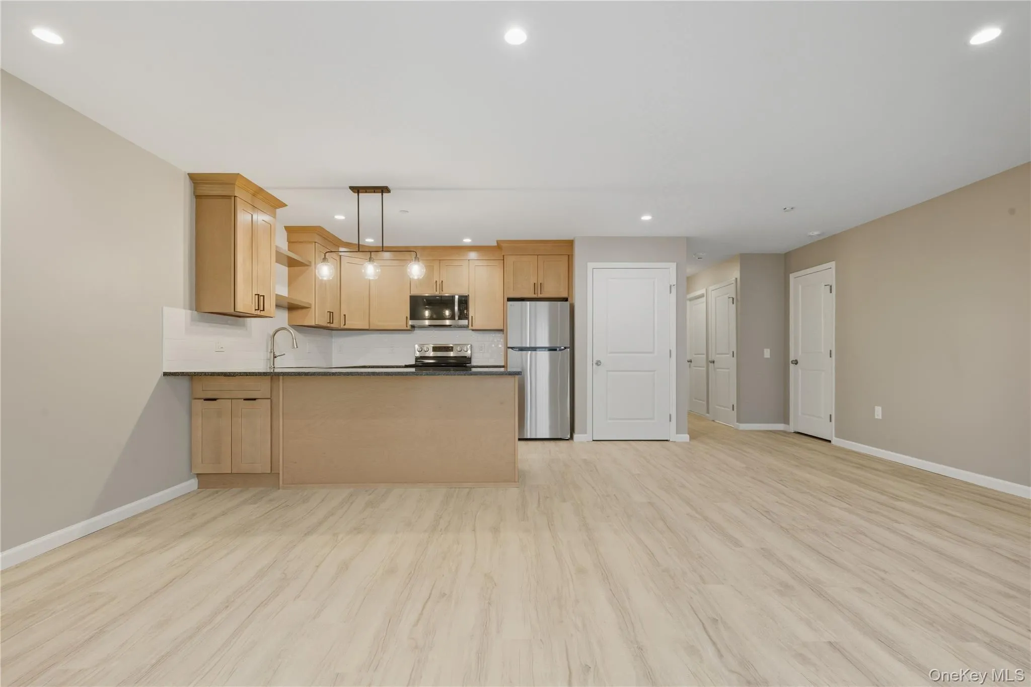 Kitchen Featuring Decorative Pendant Light Fixtures, Luxury Vinyl Plank Flooring, Stainless Steel Appliances, Wood Cabinetry & Granite Countertops w/Tile Backsplash Kitchen Featuring Decorative Pendant Light Fixtures, Luxury Vinyl Plank Flooring, Stainless Steel Appliances, Wood Cabinetry & Granite Countertops w/Tile Backsplash