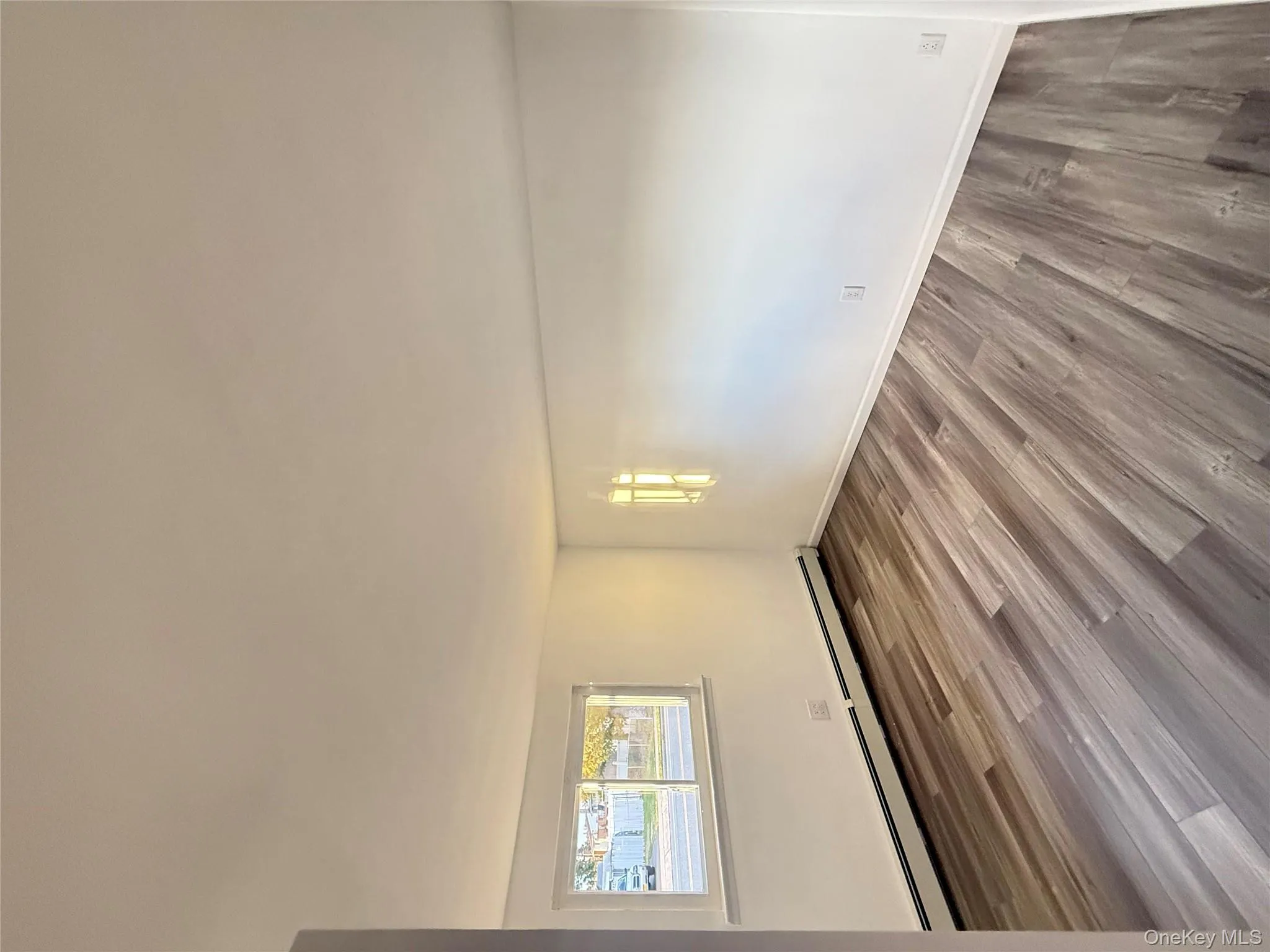 Unfurnished room with light wood-type flooring and baseboard heating Unfurnished room with light wood-type flooring and baseboard heating