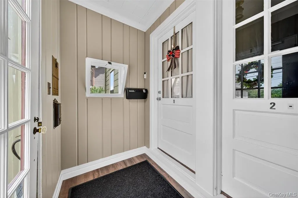 Doorway to outside featuring wood finished floors and crown molding Doorway to outside featuring wood finished floors and crown molding