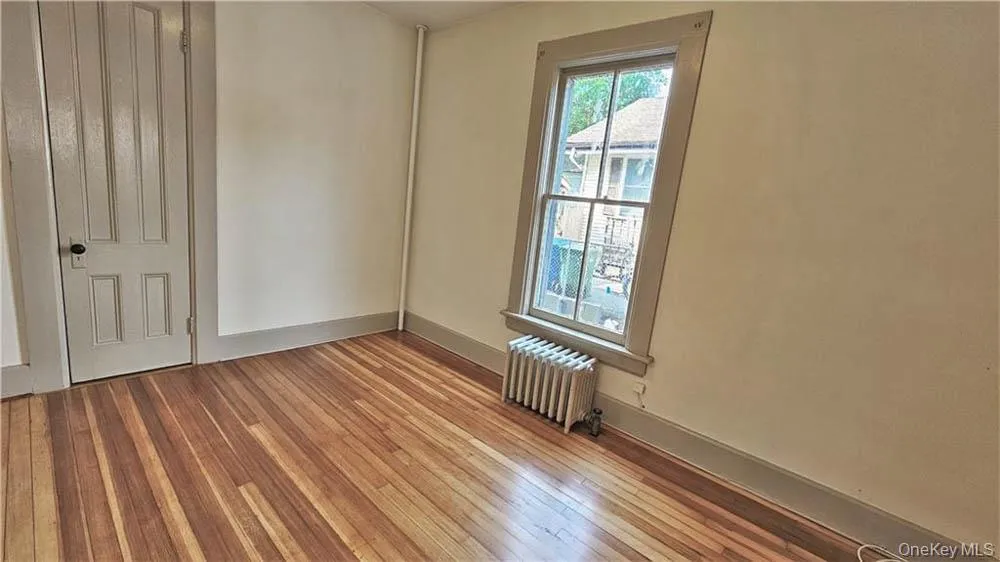 Spare room with radiator heating unit and wood-type flooring Spare room with radiator heating unit and wood-type flooring