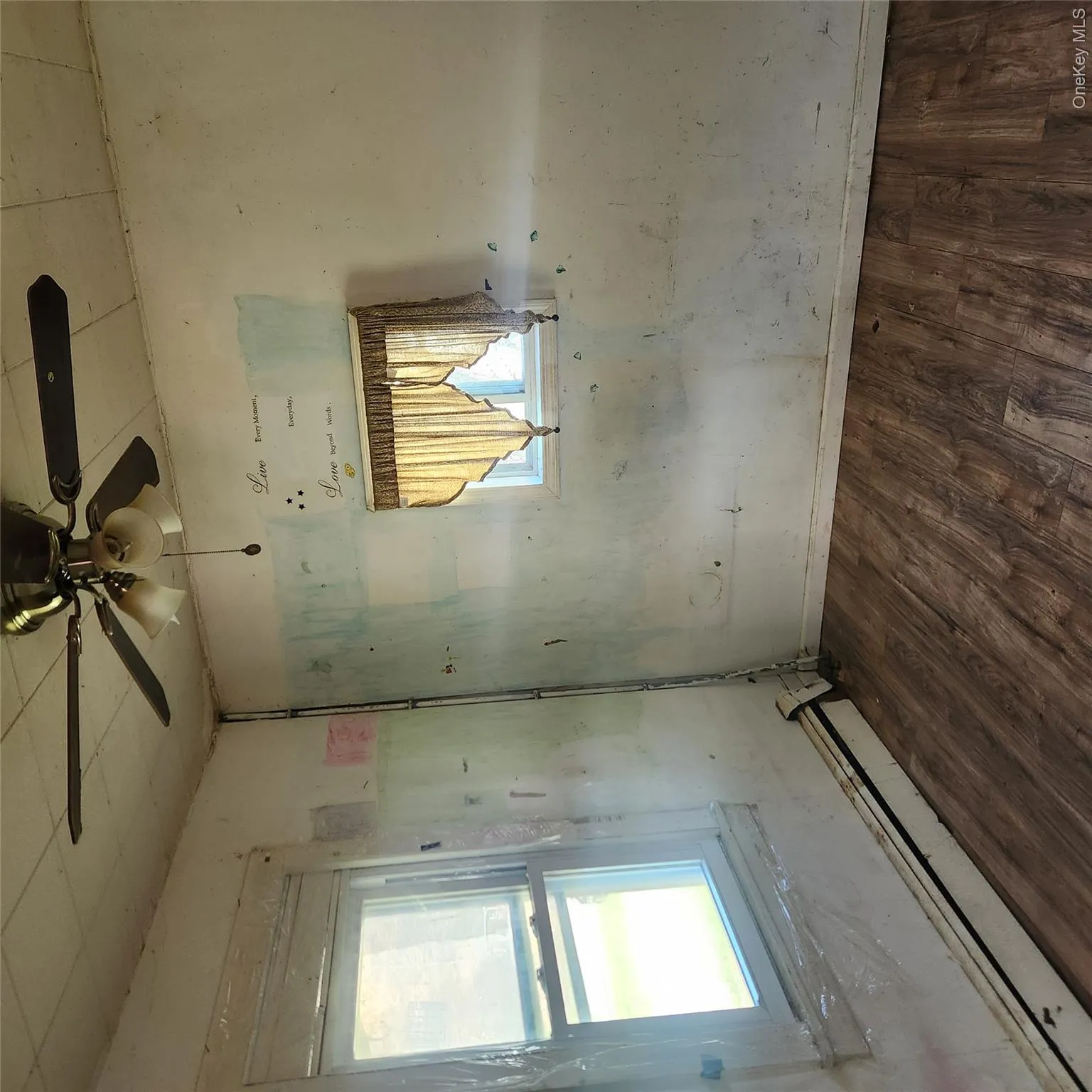 Empty room featuring a baseboard radiator, dark wood-style flooring, and a ceiling fan Empty room featuring a baseboard radiator, dark wood-style flooring, and a ceiling fan