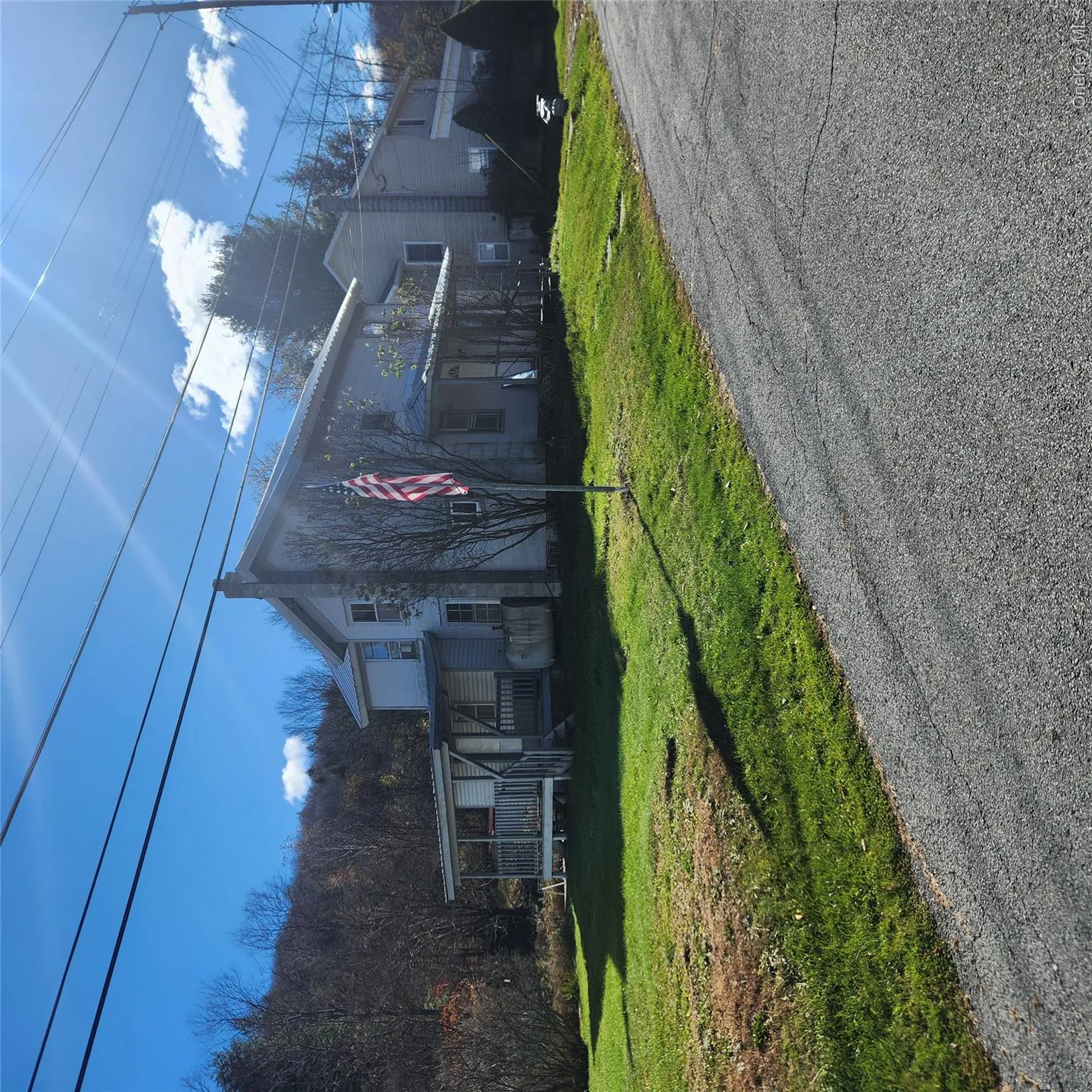 View of front facade with a front lawn, a chimney, and a porch View of front facade with a front lawn, a chimney, and a porch