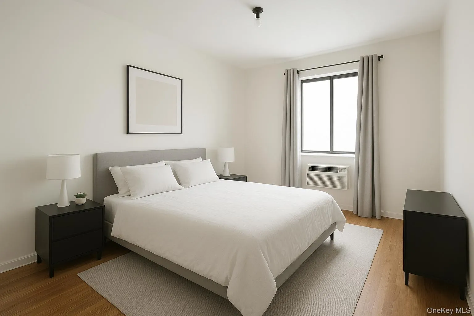 Bedroom with light wood finished floors and a wall mounted air conditioner Bedroom with light wood finished floors and a wall mounted air conditioner
