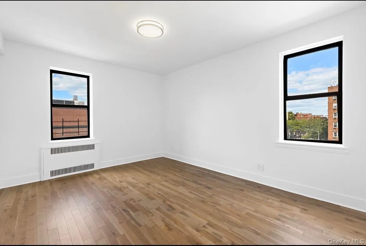Spare room featuring light wood finished floors and radiator Spare room featuring light wood finished floors and radiator