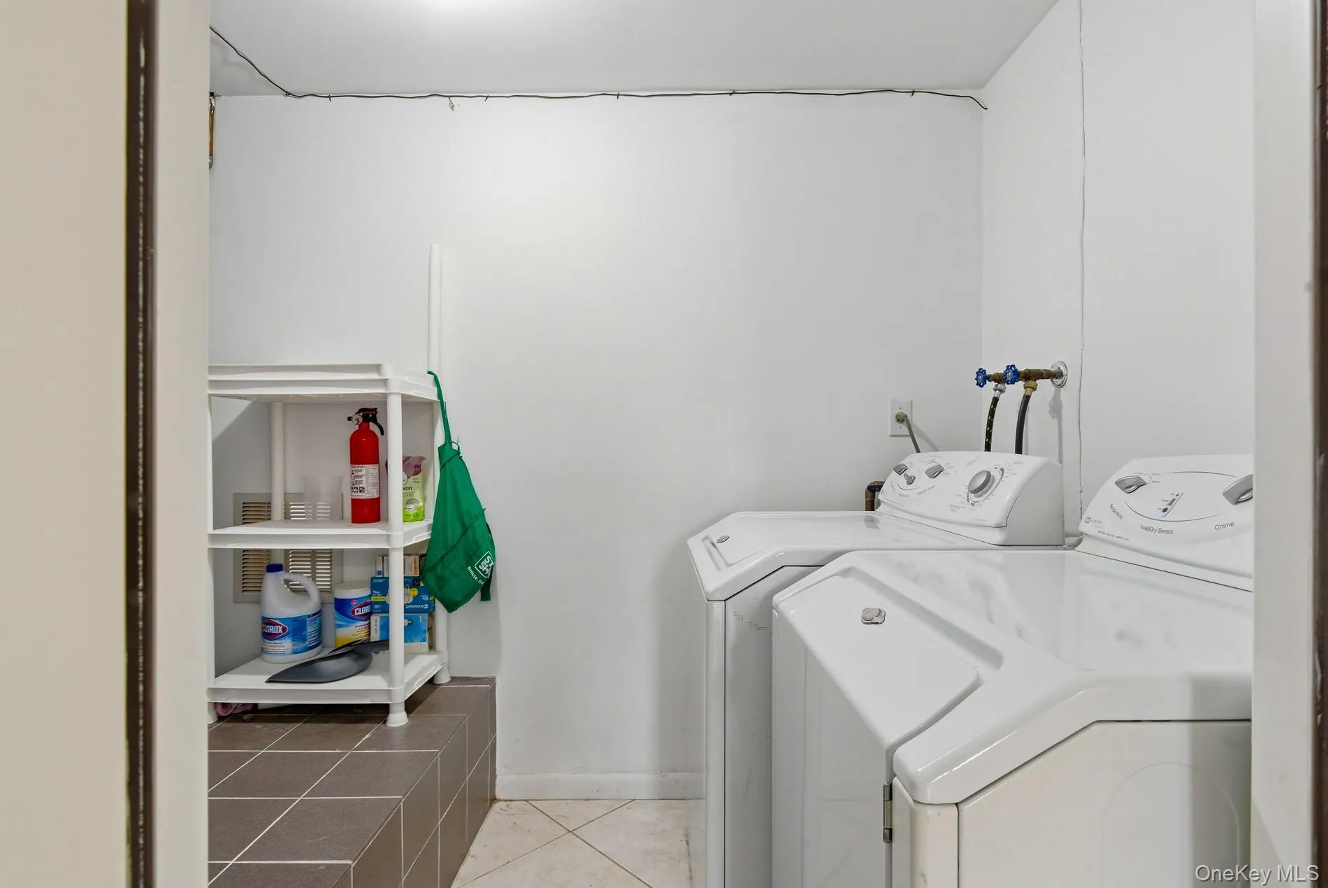 Laundry room featuring washer and dryer and light tile patterned floors Laundry room featuring washer and dryer and light tile patterned floors
