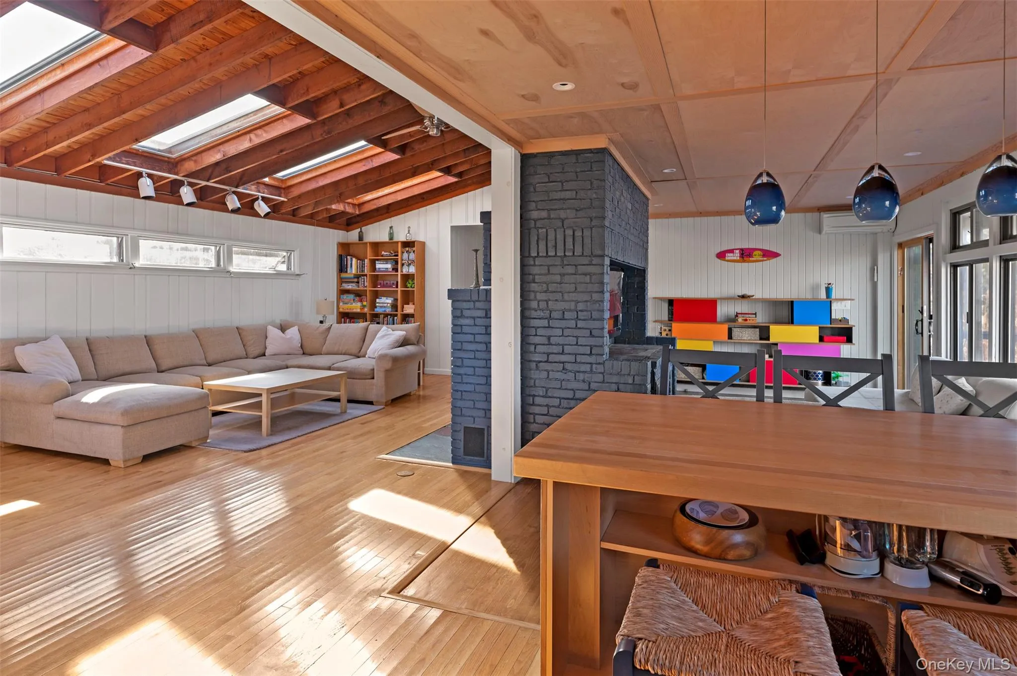 Dining space featuring a skylight, vaulted ceiling, hardwood / wood-style flooring, and wooden walls Dining space featuring a skylight, vaulted ceiling, hardwood / wood-style flooring, and wooden walls
