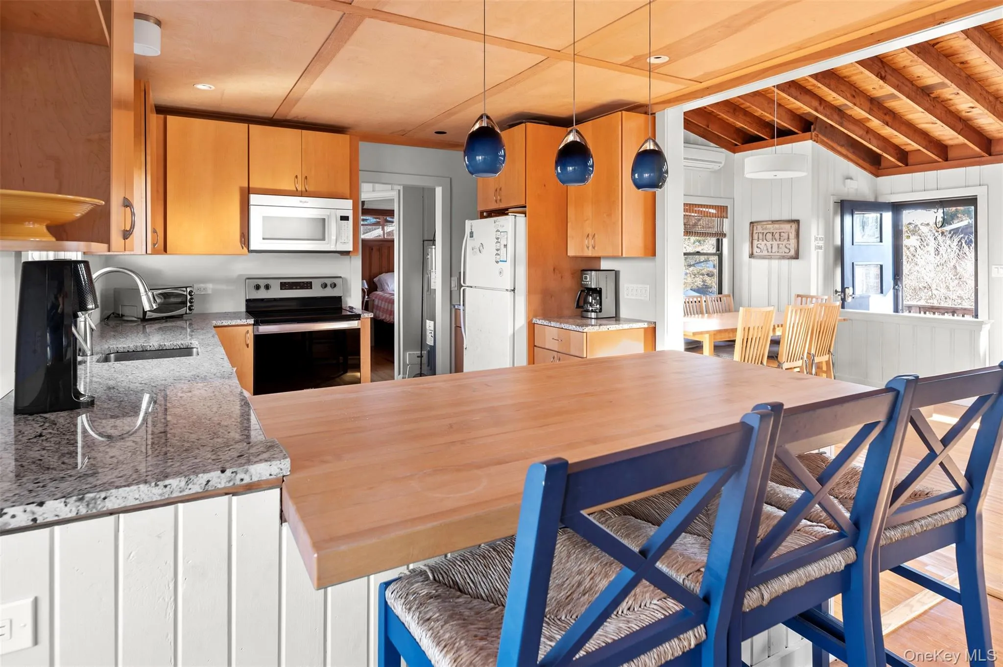 Kitchen with white appliances, light stone countertops, hanging light fixtures, a wooden ceiling with exposed beams, and light wood-type flooring Kitchen with white appliances, light stone countertops, hanging light fixtures, a wooden ceiling with exposed beams, and light wood-type flooring