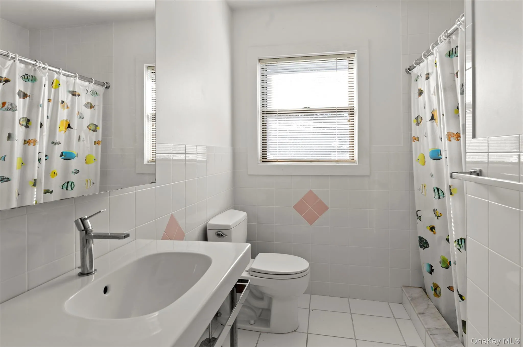 Full bathroom featuring tile walls, curtained shower, light tile patterned flooring, and vanity Full bathroom featuring tile walls, curtained shower, light tile patterned flooring, and vanity