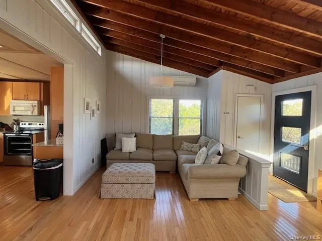 Living room with light wood-style floors and wooden walls Living room with light wood-style floors and wooden walls