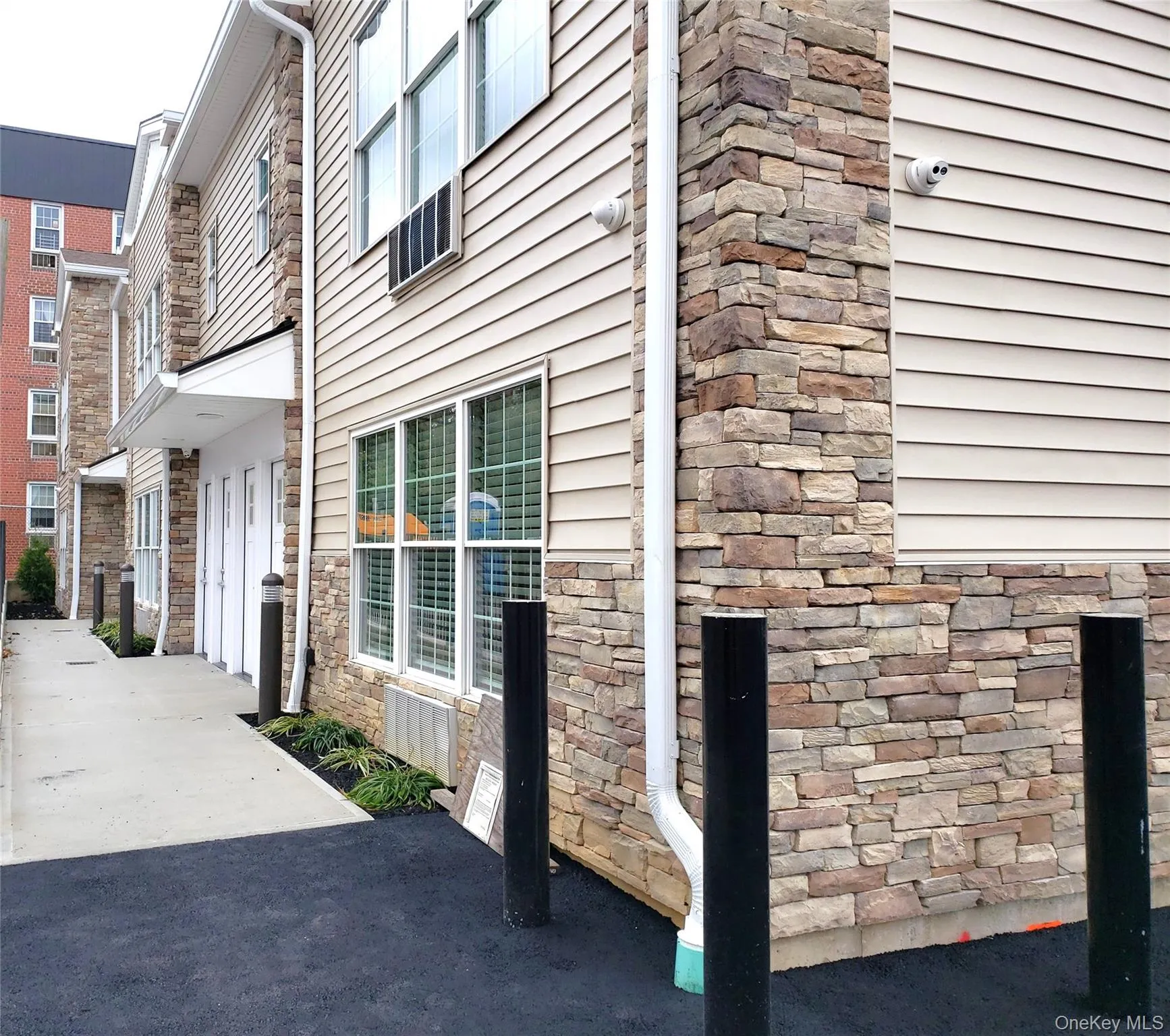 View of side of property featuring stone siding and a security system View of side of property featuring stone siding and a security system