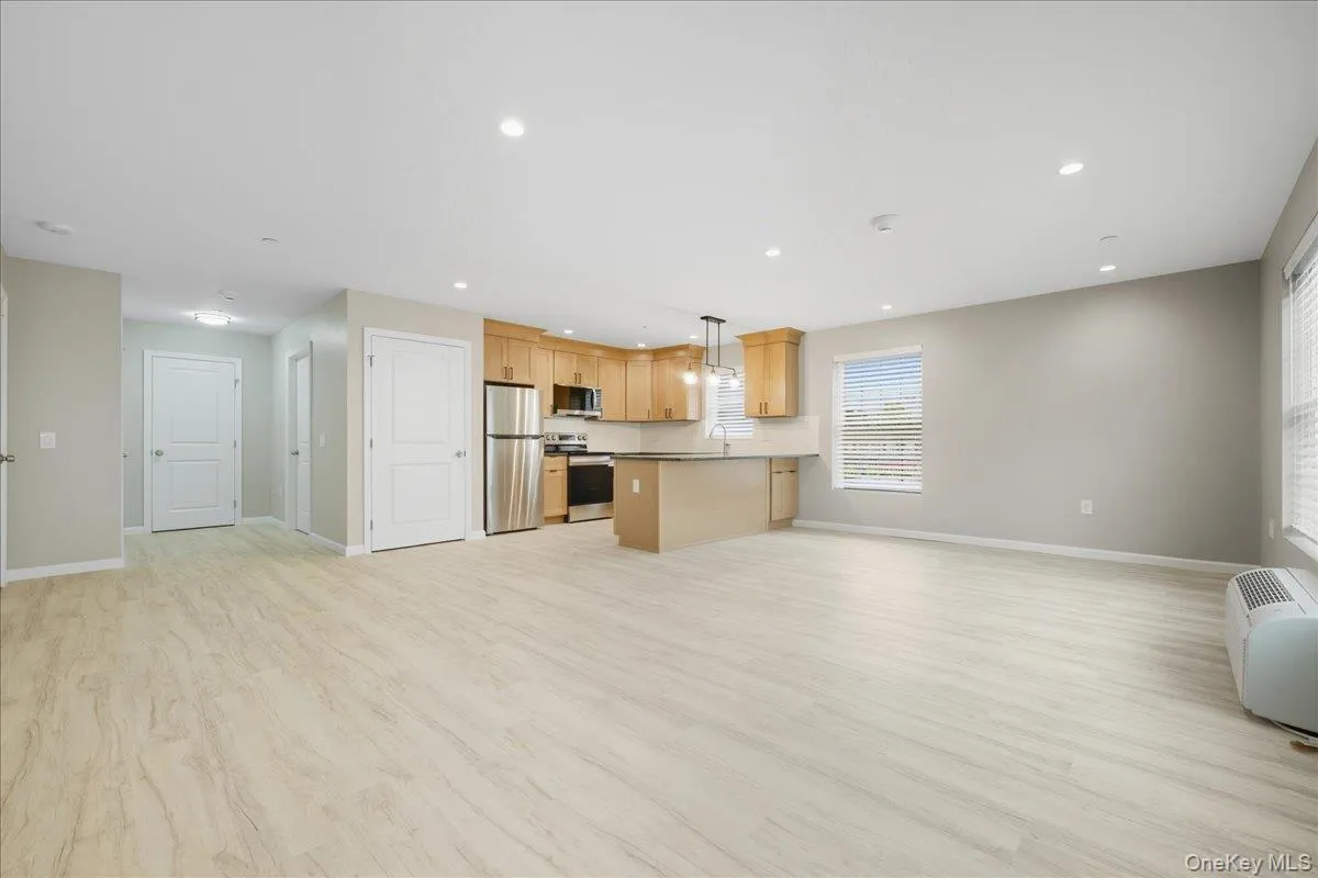Living Room & Kitchen featuring Open Floor Plan, Luxury Vinyl Plank Floors, and Recessed Lighting Living Room & Kitchen featuring Open Floor Plan, Luxury Vinyl Plank Floors, and Recessed Lighting