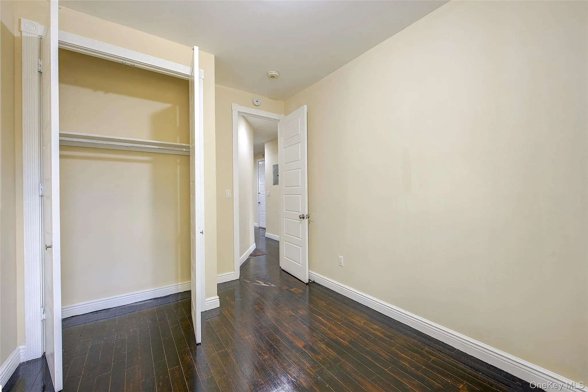 Unfurnished bedroom featuring dark wood-style floors and a closet Unfurnished bedroom featuring dark wood-style floors and a closet