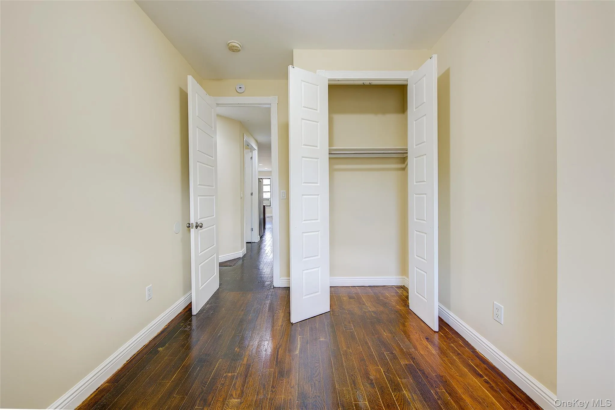 Unfurnished bedroom with dark wood-type flooring and a closet Unfurnished bedroom with dark wood-type flooring and a closet