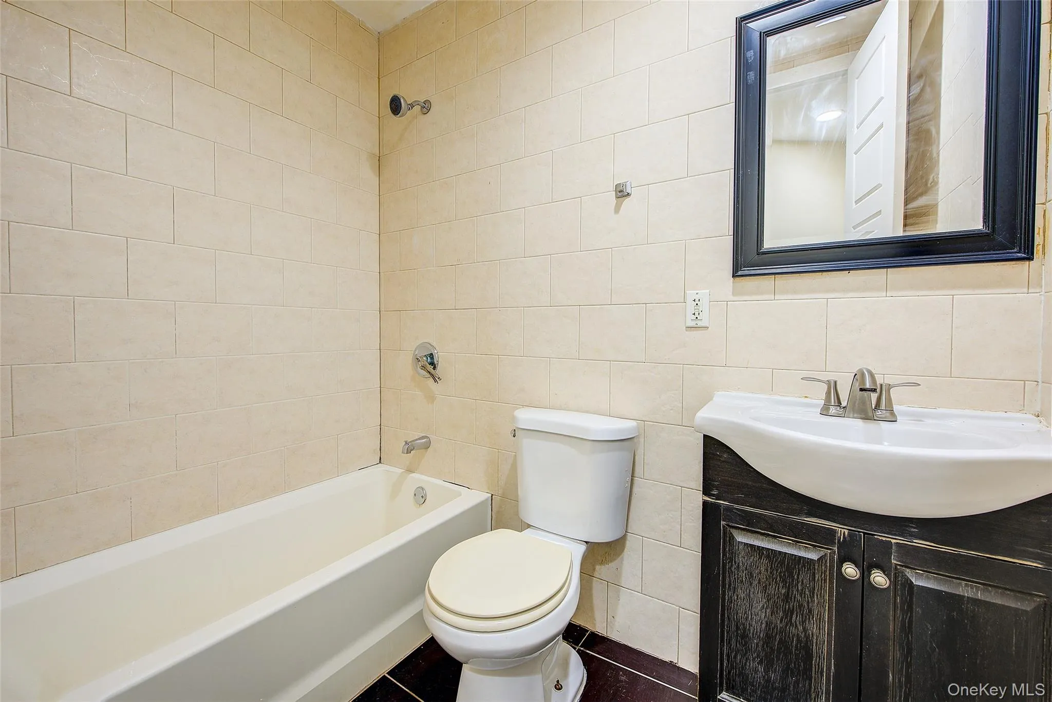 Bathroom with vanity, washtub / shower combination, and tile walls Bathroom with vanity, washtub / shower combination, and tile walls