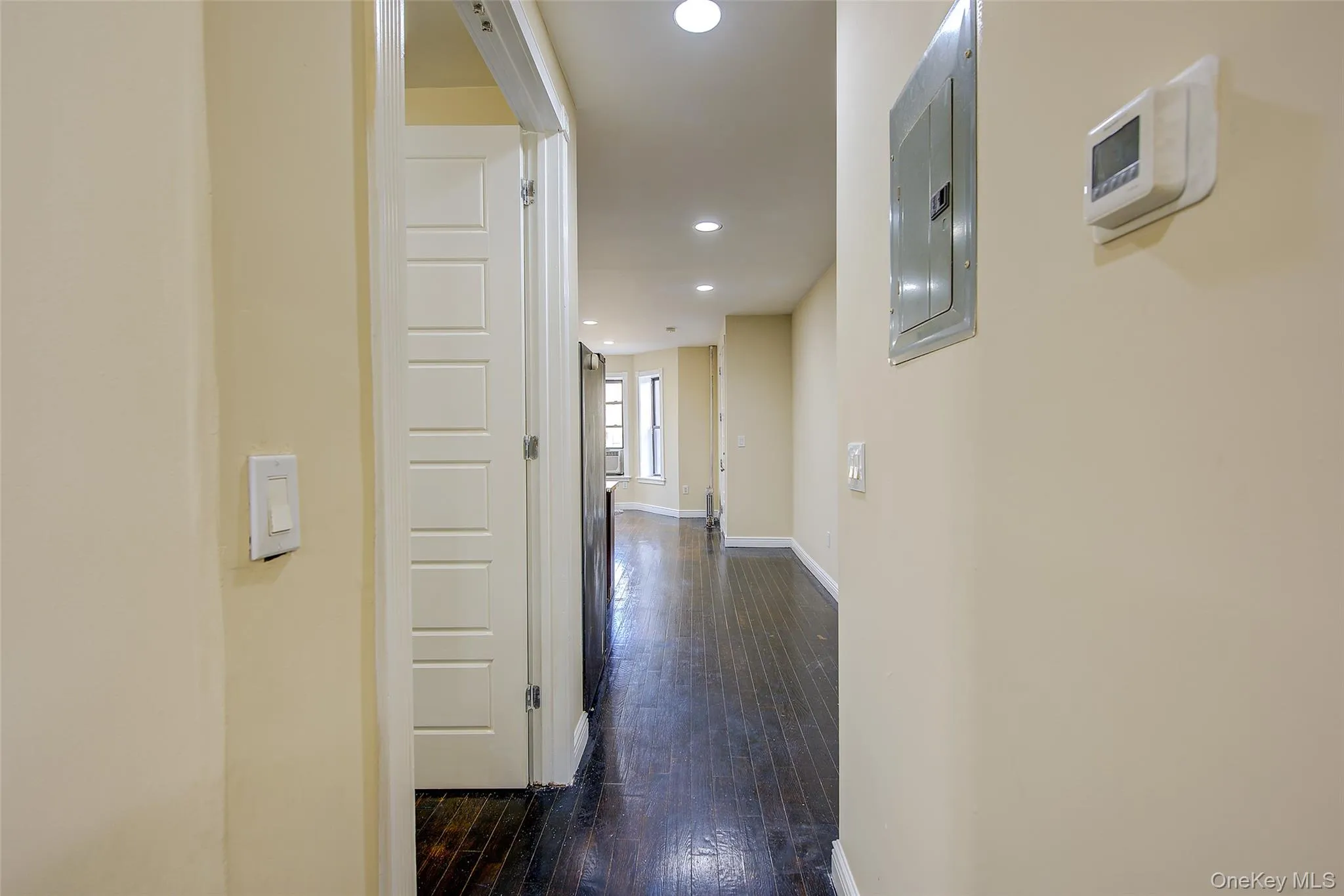 Hallway with recessed lighting, dark wood-style floors, and electric panel Hallway with recessed lighting, dark wood-style floors, and electric panel