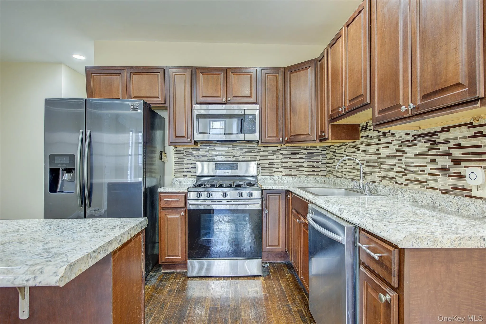 Kitchen with stainless steel appliances, brown cabinets, and recessed lighting Kitchen with stainless steel appliances, brown cabinets, and recessed lighting