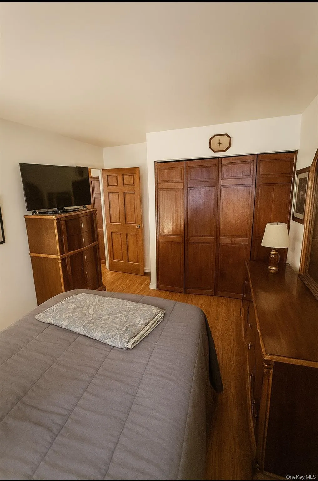 Bedroom featuring wood finished floors and a closet Bedroom featuring wood finished floors and a closet