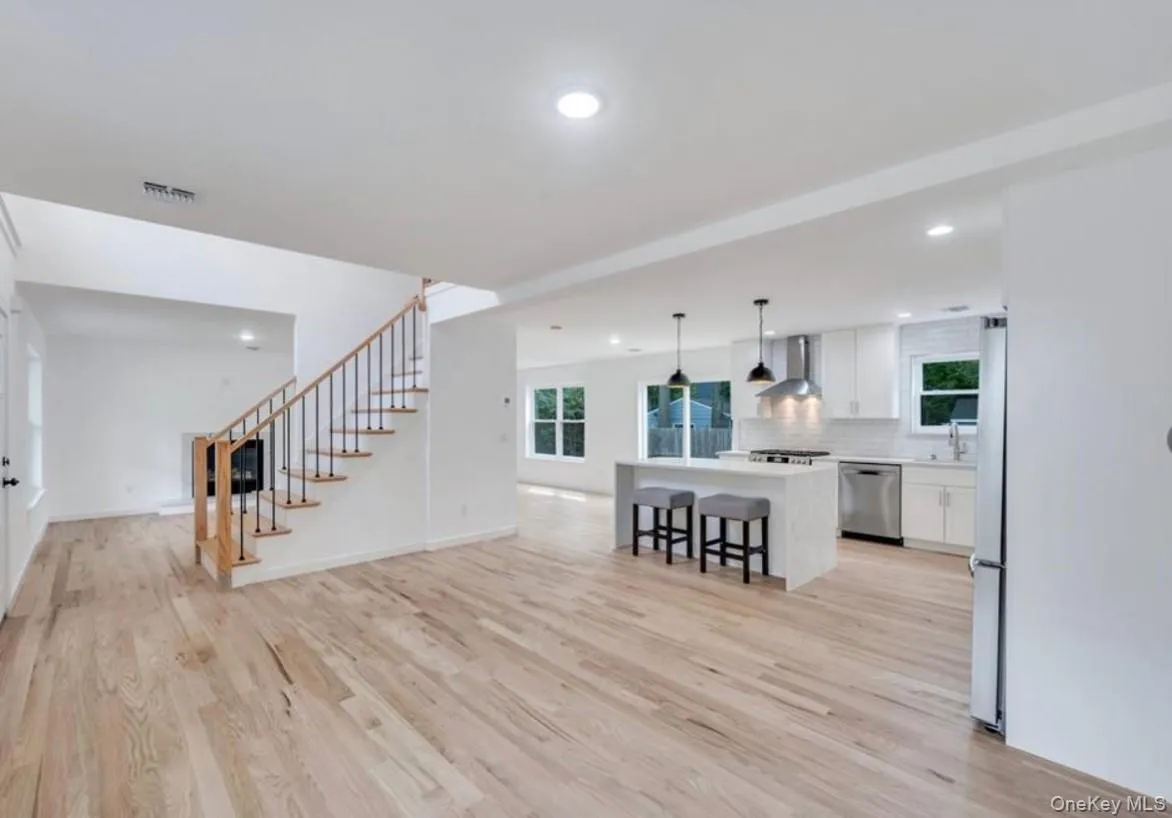 Living area with healthy amount of natural light, light wood-type flooring, and recessed lighting Living area with healthy amount of natural light, light wood-type flooring, and recessed lighting