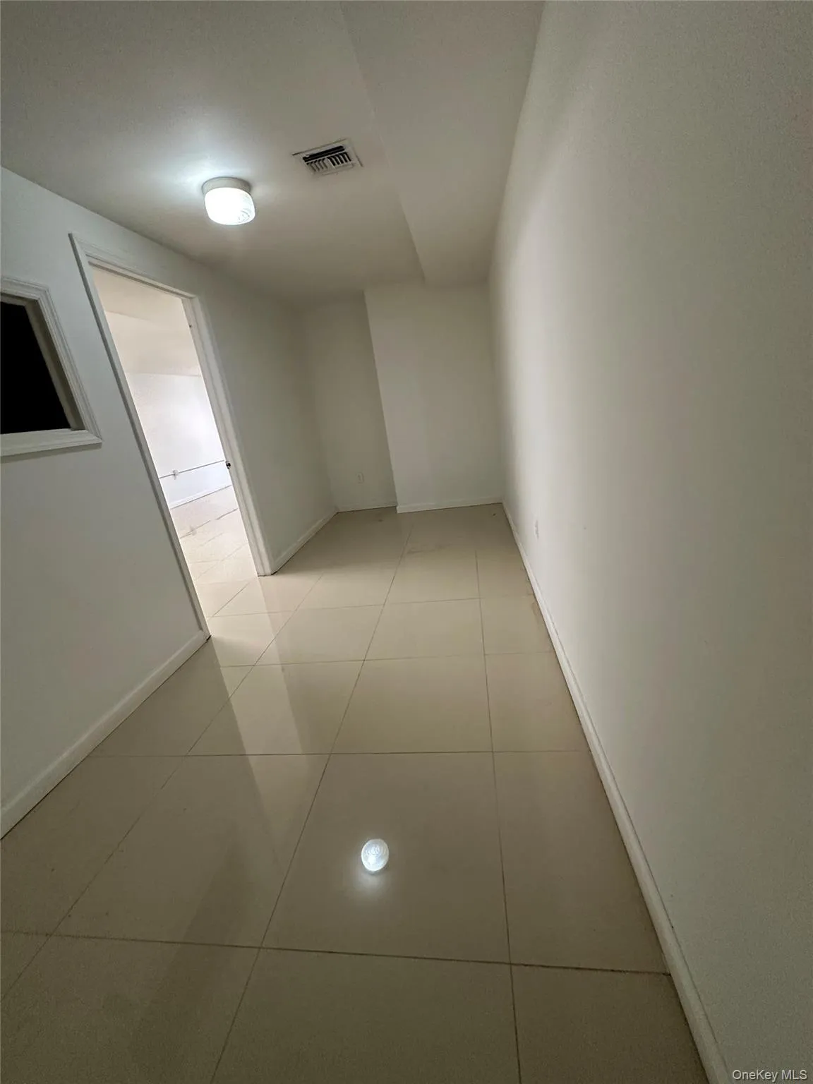 Corridor featuring light tile patterned floors Corridor featuring light tile patterned floors