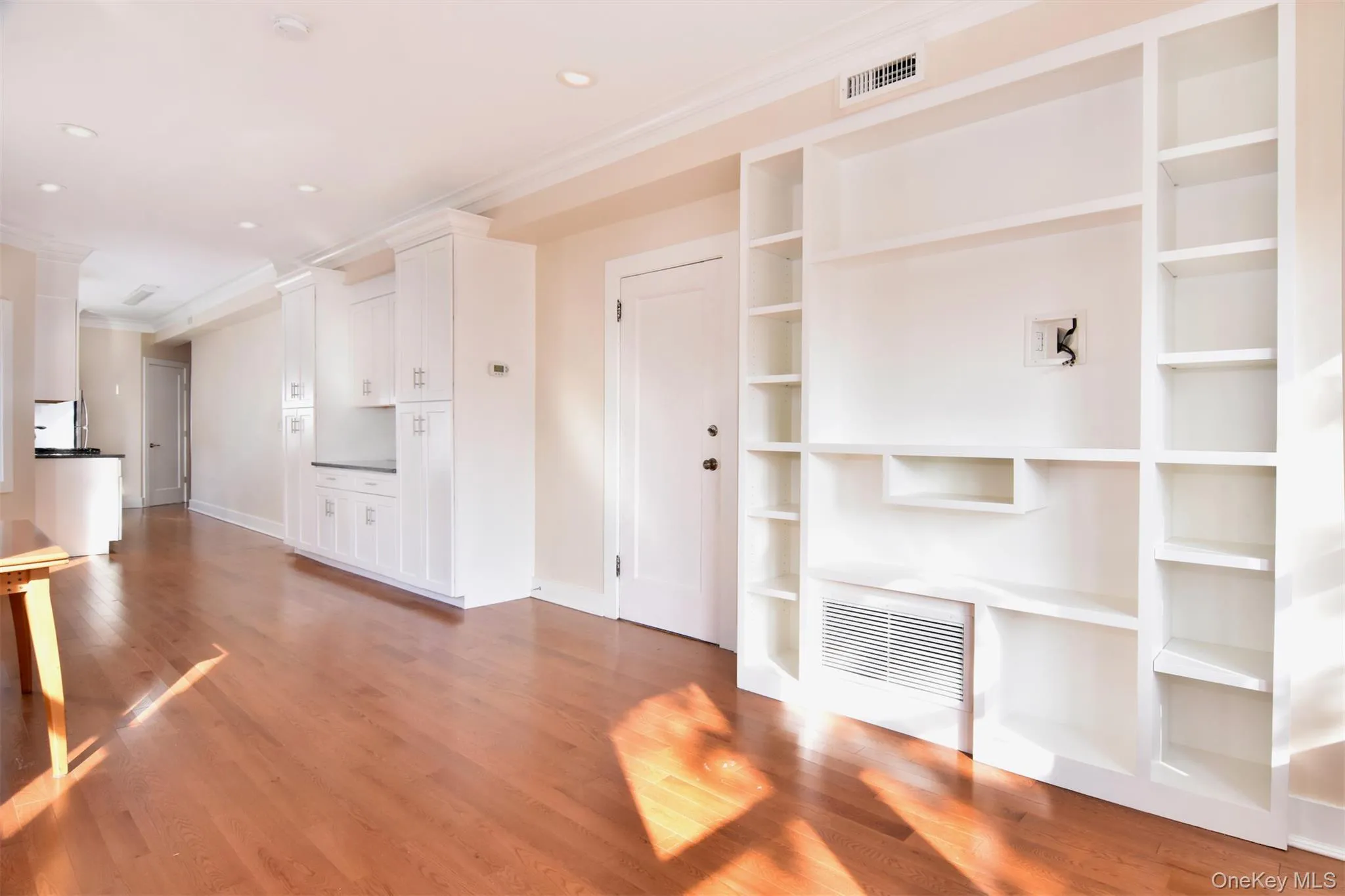 Unfurnished living room featuring light wood-type flooring, crown molding, and recessed lighting Unfurnished living room featuring light wood-type flooring, crown molding, and recessed lighting
