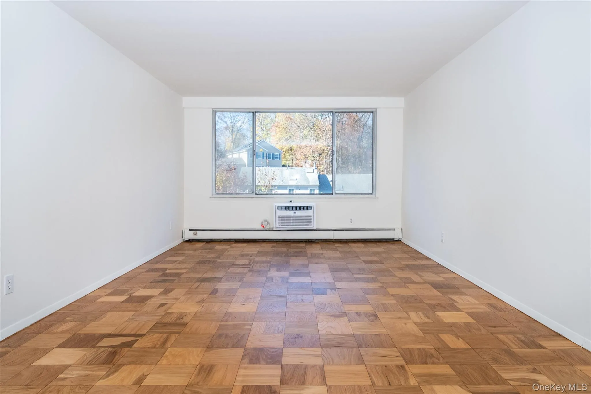 Empty room with a wall mounted AC and a baseboard radiator Empty room with a wall mounted AC and a baseboard radiator