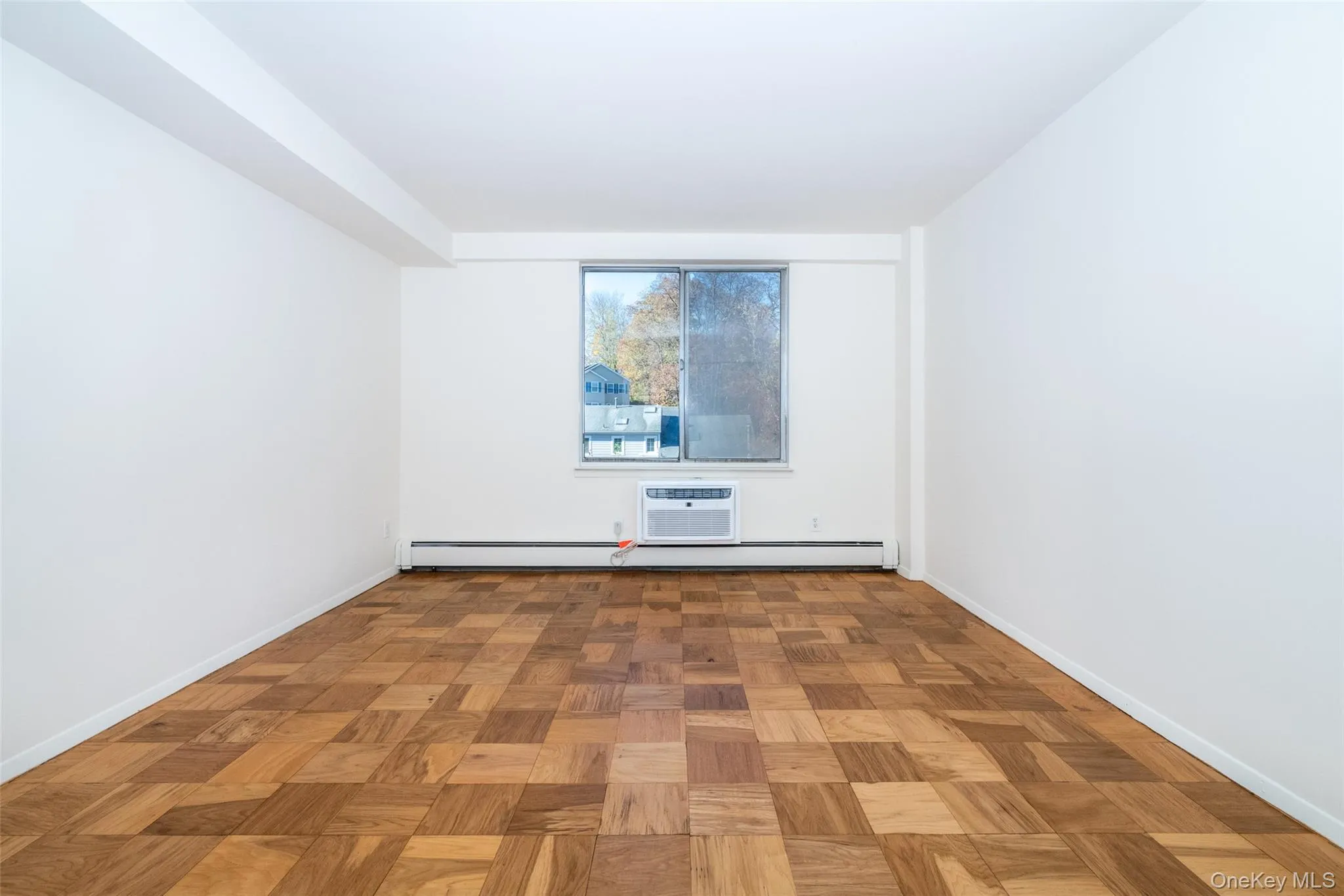 Unfurnished room with an AC wall unit and a baseboard radiator Unfurnished room with an AC wall unit and a baseboard radiator