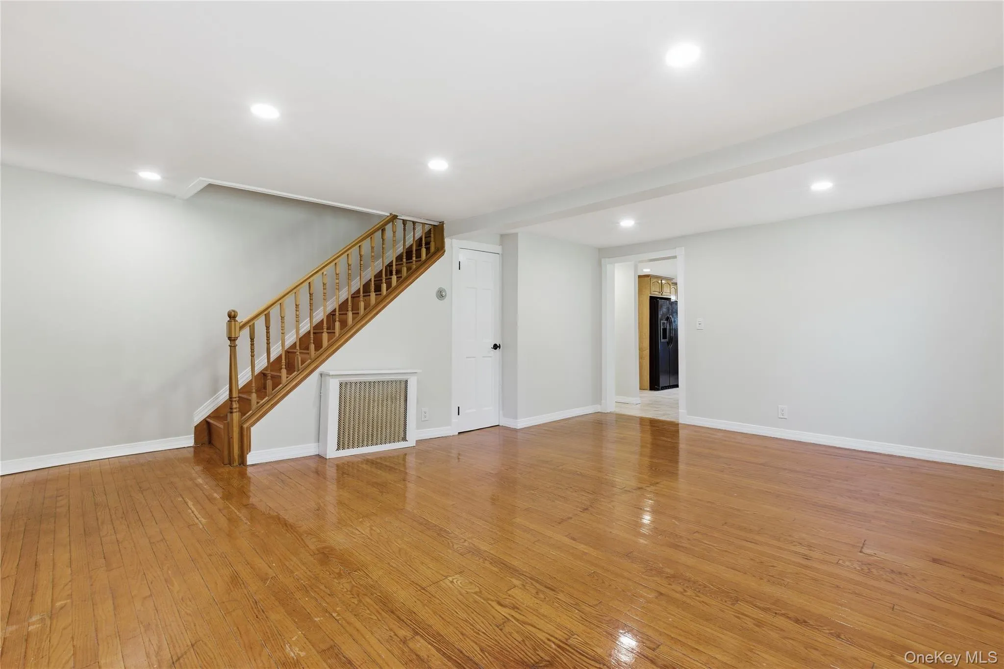 Unfurnished living room with recessed lighting, light wood-style flooring, and stairs Unfurnished living room with recessed lighting, light wood-style flooring, and stairs