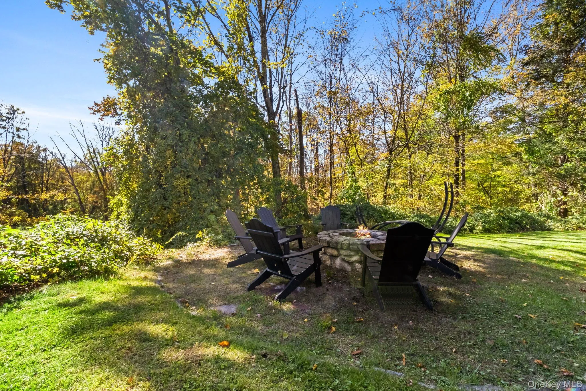 View of grassy yard featuring a patio area and a fire pit View of grassy yard featuring a patio area and a fire pit