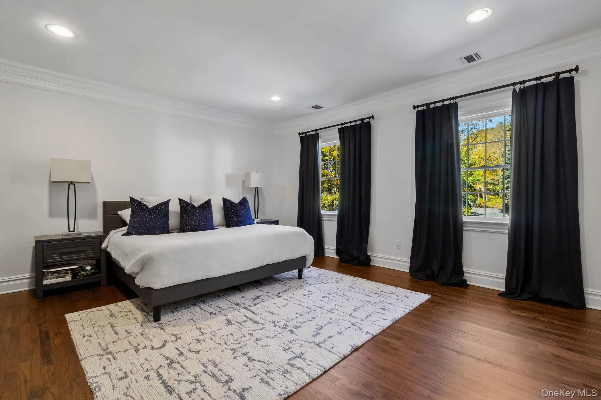 Bedroom with crown molding, multiple windows, dark wood-style flooring, and recessed lighting Bedroom with crown molding, multiple windows, dark wood-style flooring, and recessed lighting