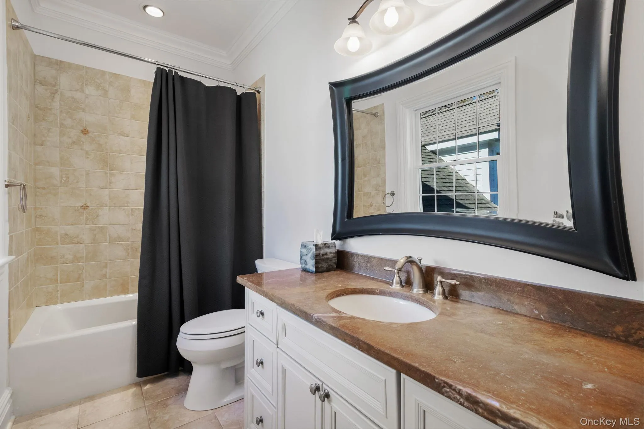 Bathroom featuring shower / bathtub combination with curtain, vanity, ornamental molding, and light tile patterned flooring Bathroom featuring shower / bathtub combination with curtain, vanity, ornamental molding, and light tile patterned flooring
