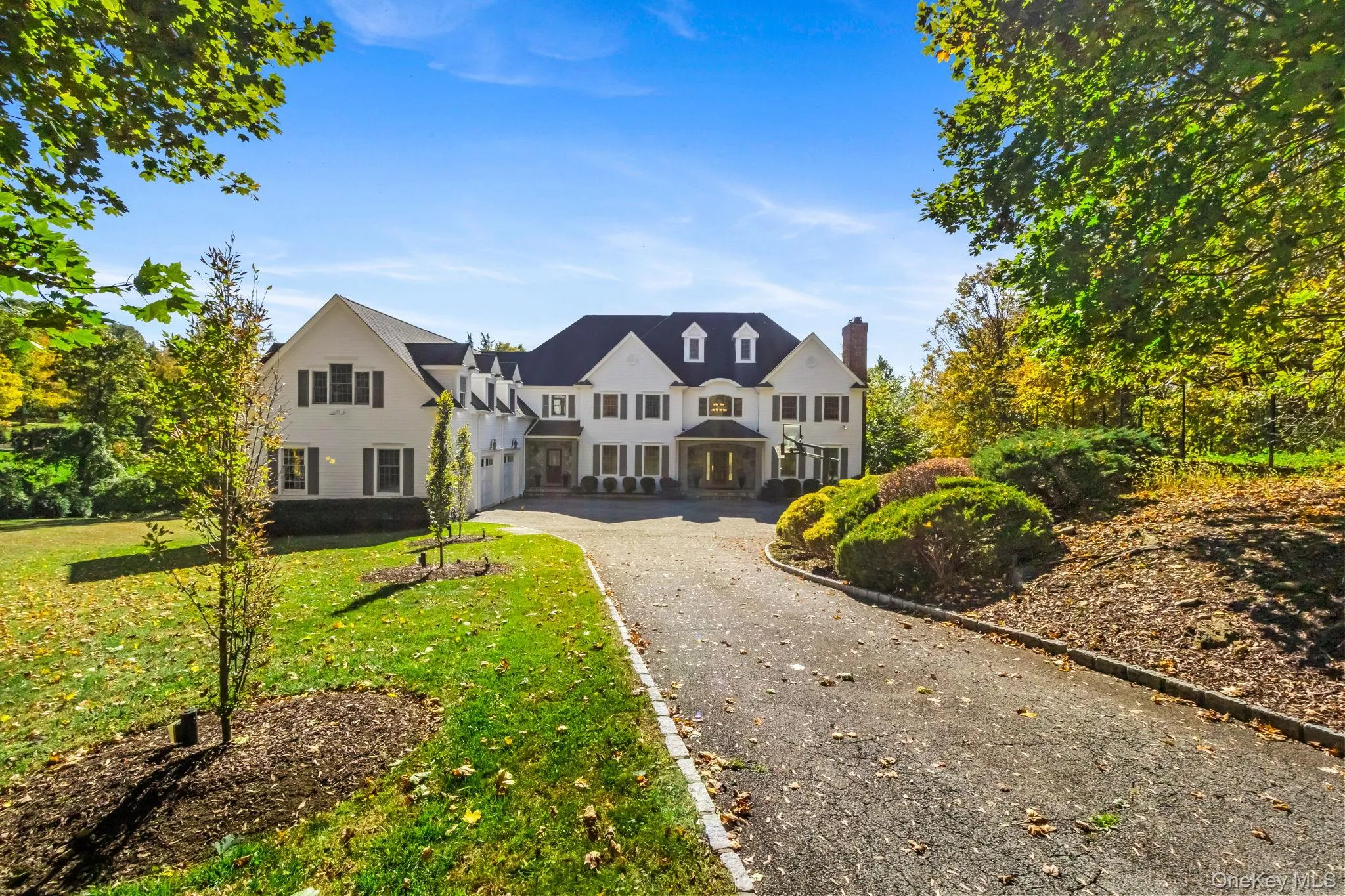 View of front of property with driveway, a garage, a front lawn, and a chimney View of front of property with driveway, a garage, a front lawn, and a chimney