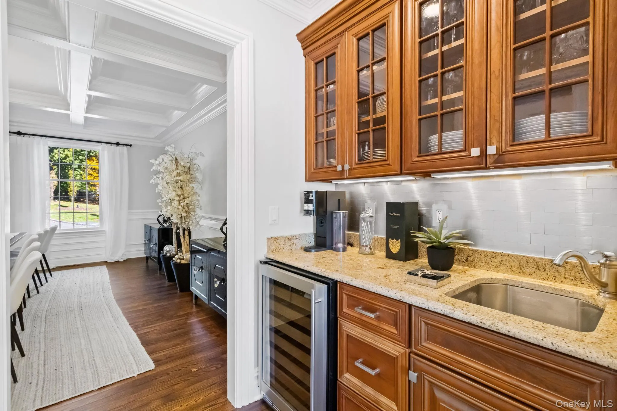 Bar area featuring light stone countertops, coffered ceiling, beverage cooler, beam ceiling, and ornamental molding Bar area featuring light stone countertops, coffered ceiling, beverage cooler, beam ceiling, and ornamental molding
