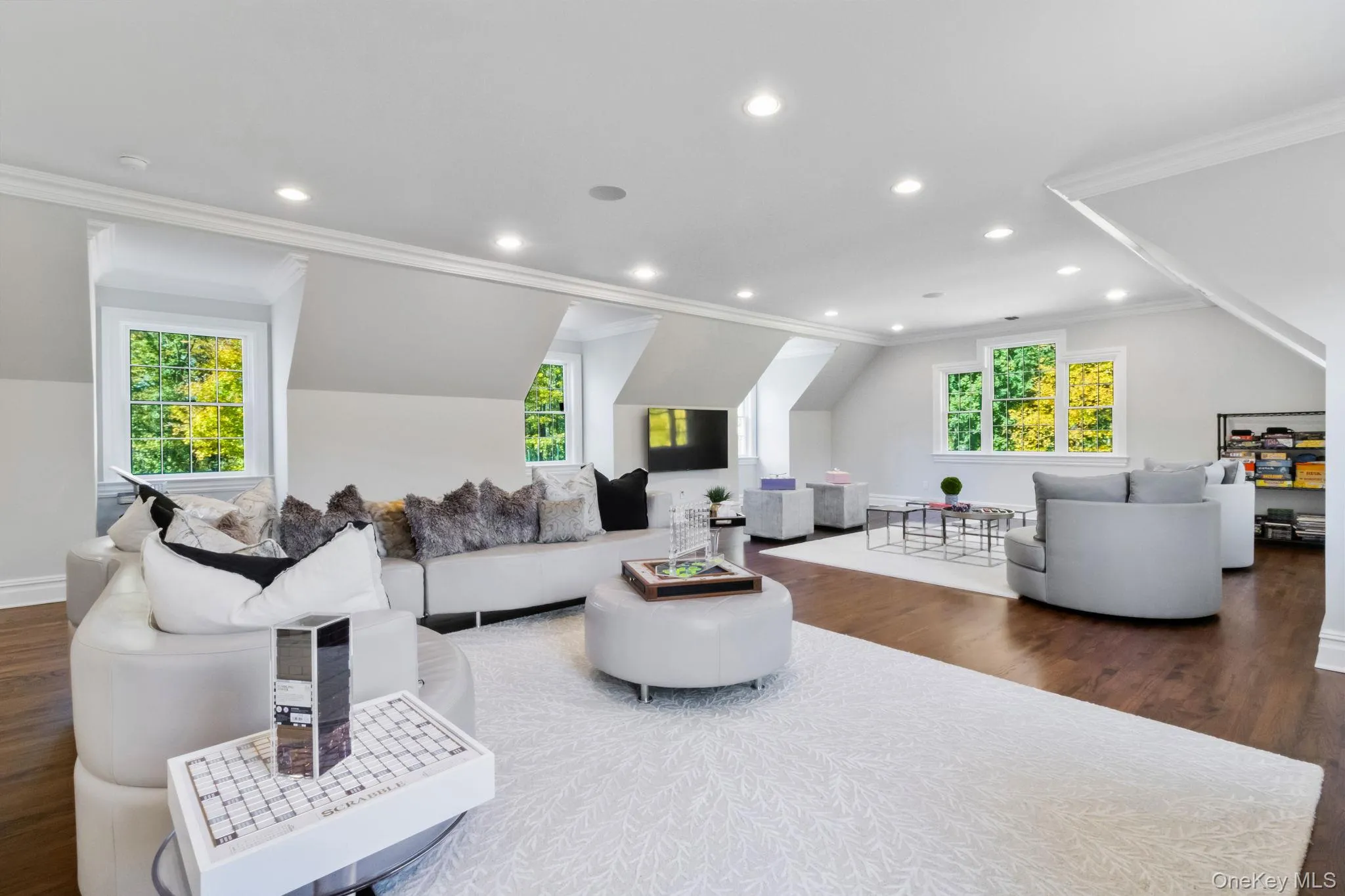 Living room with crown molding, dark wood finished floors, plenty of natural light, lofted ceiling, and recessed lighting Living room with crown molding, dark wood finished floors, plenty of natural light, lofted ceiling, and recessed lighting