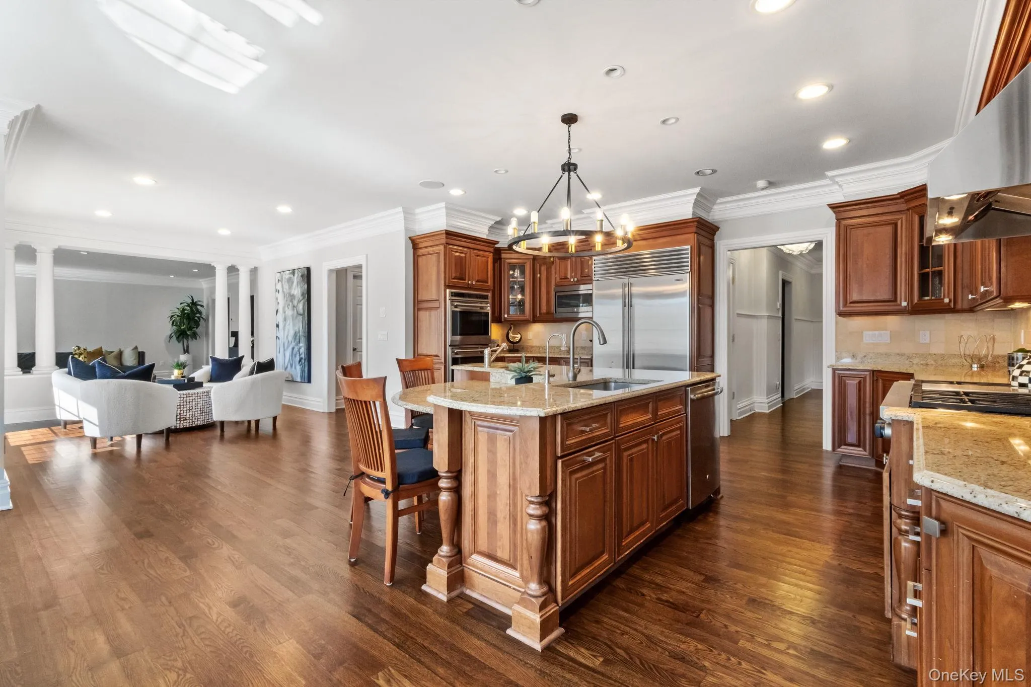 Kitchen featuring glass insert cabinets, backsplash, light stone counters, recessed lighting, and hanging light fixtures Kitchen featuring glass insert cabinets, backsplash, light stone counters, recessed lighting, and hanging light fixtures