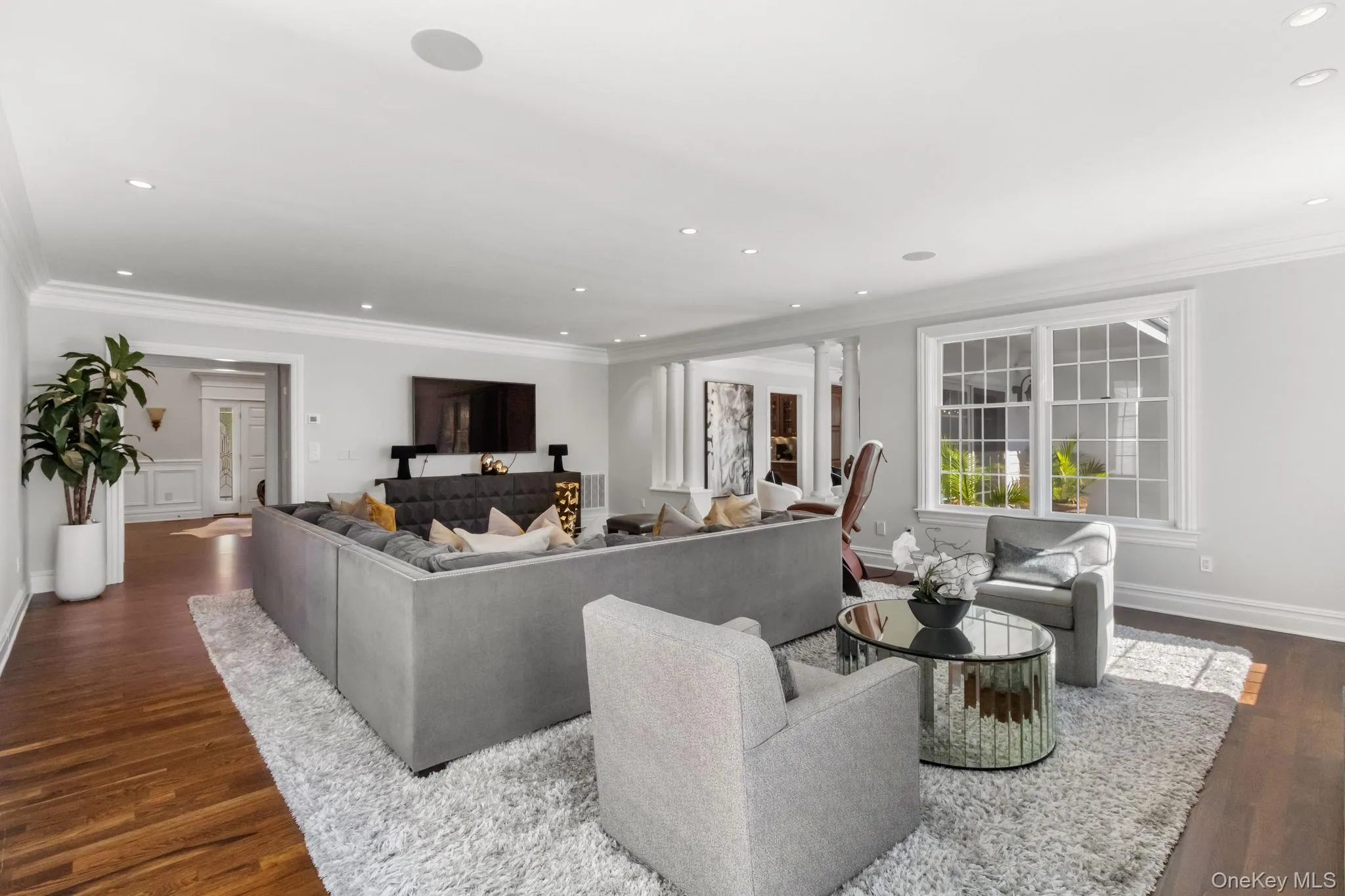 Living room with ornamental molding, dark wood-type flooring, and recessed lighting Living room with ornamental molding, dark wood-type flooring, and recessed lighting